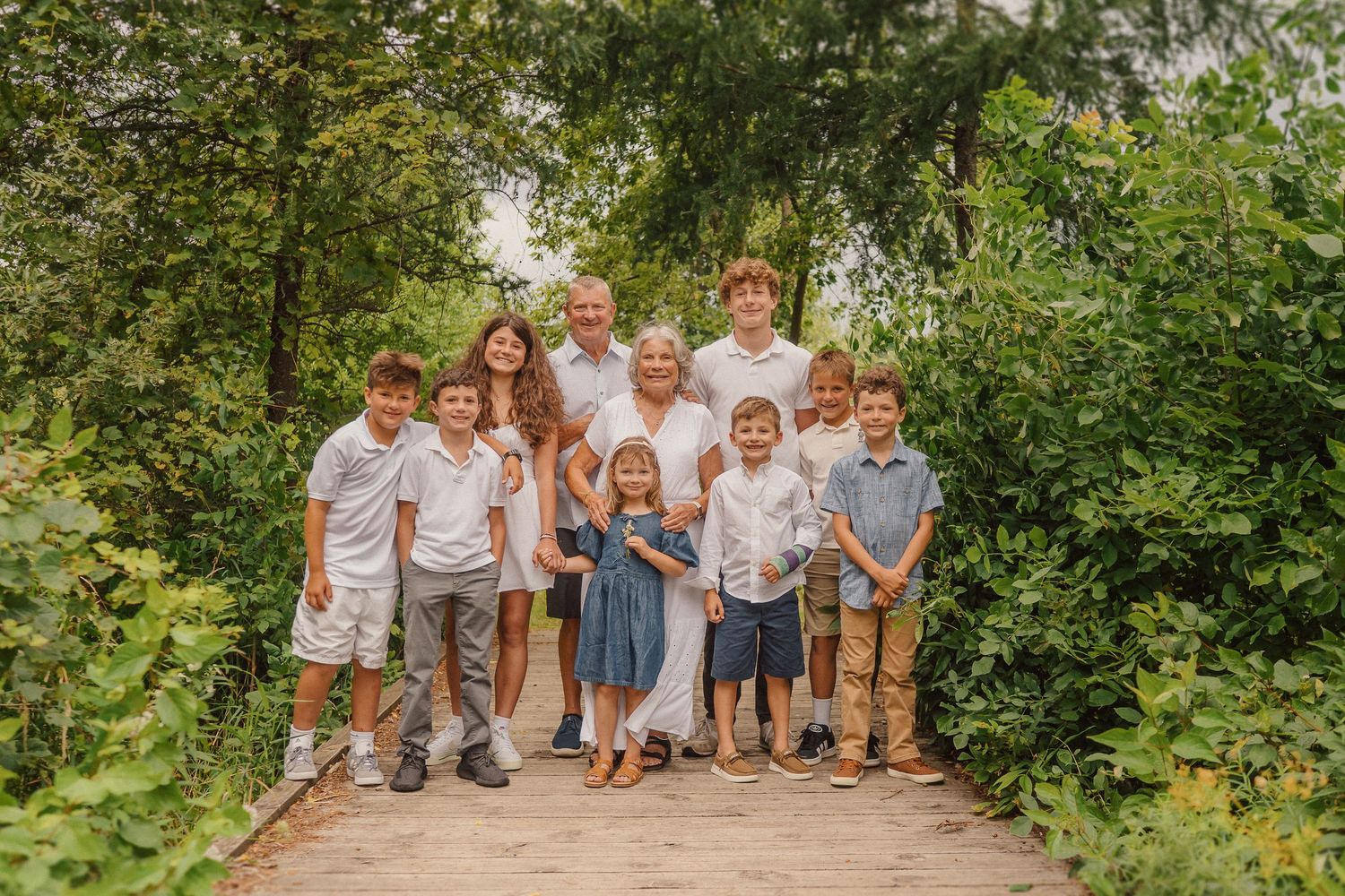 A joyful black and white family photo of people playing together in a field.