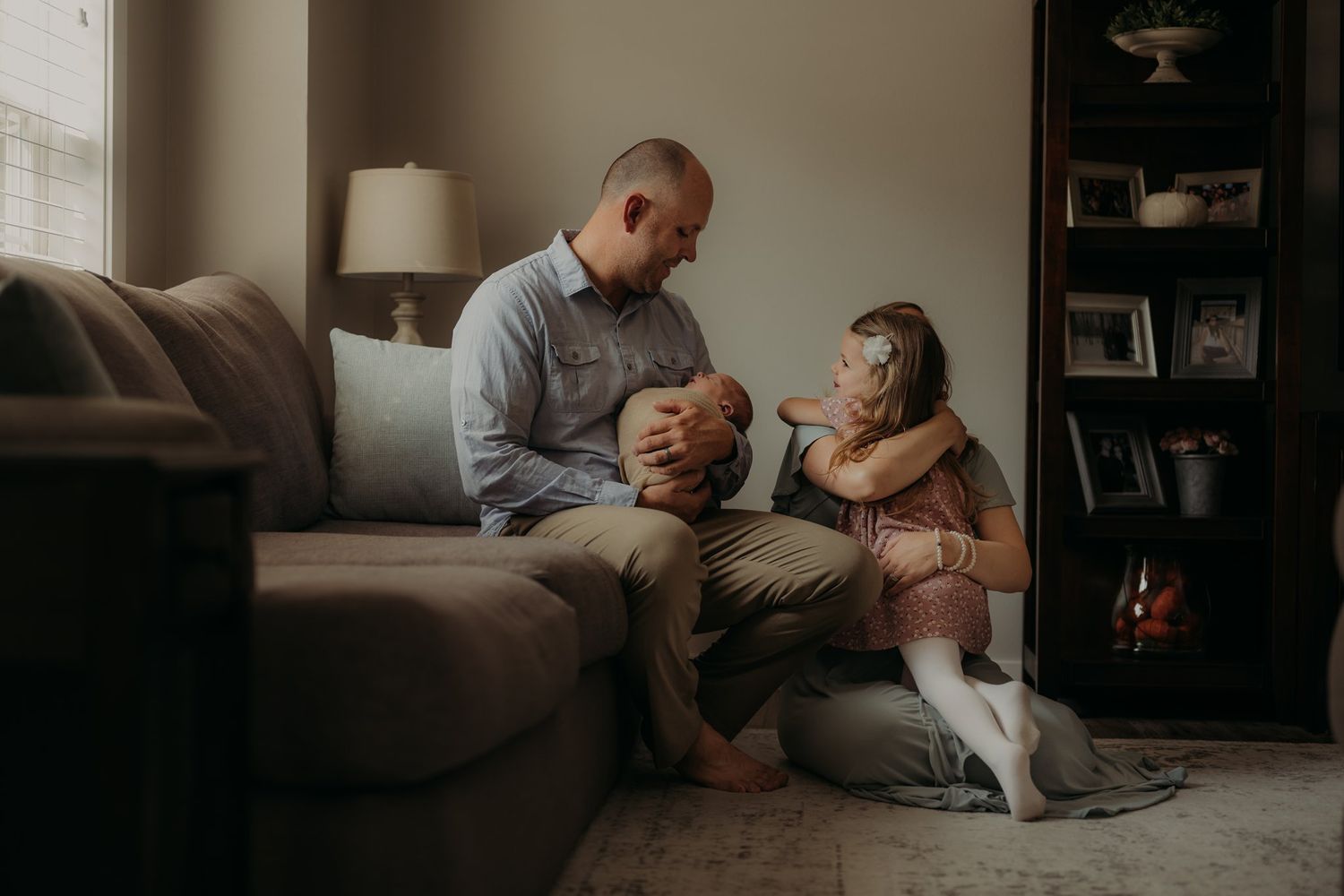 Family moment captured on living room couch with soft natural window light.
