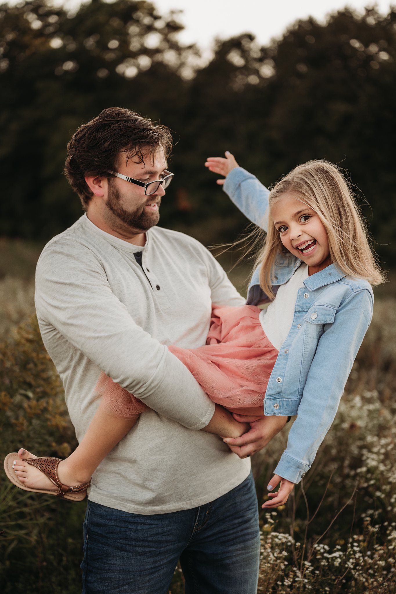 A joyful moment showing playful interaction between two people in casual attire outdoors.