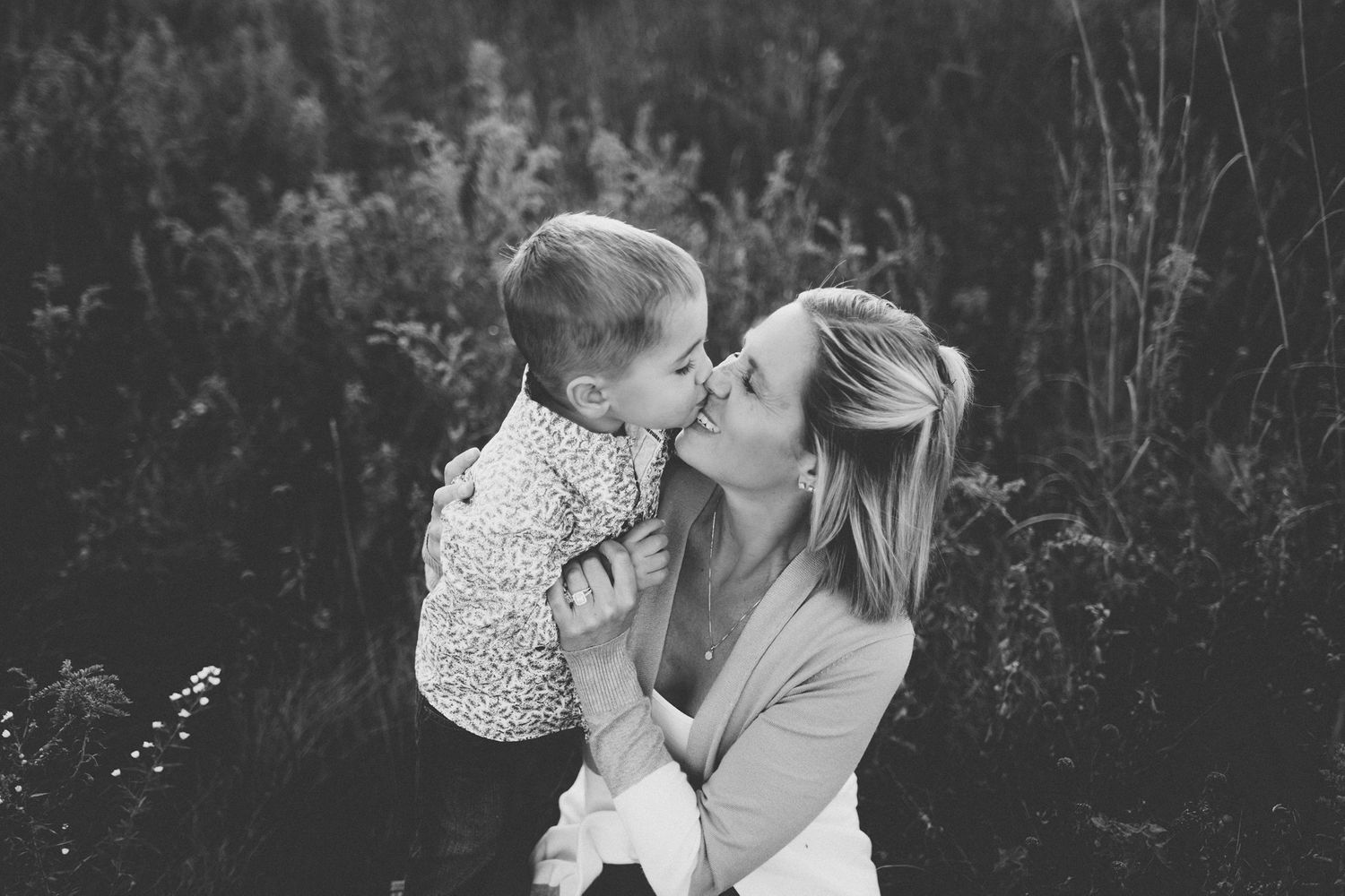 A gentle black and white portrait showing family affection outdoors.