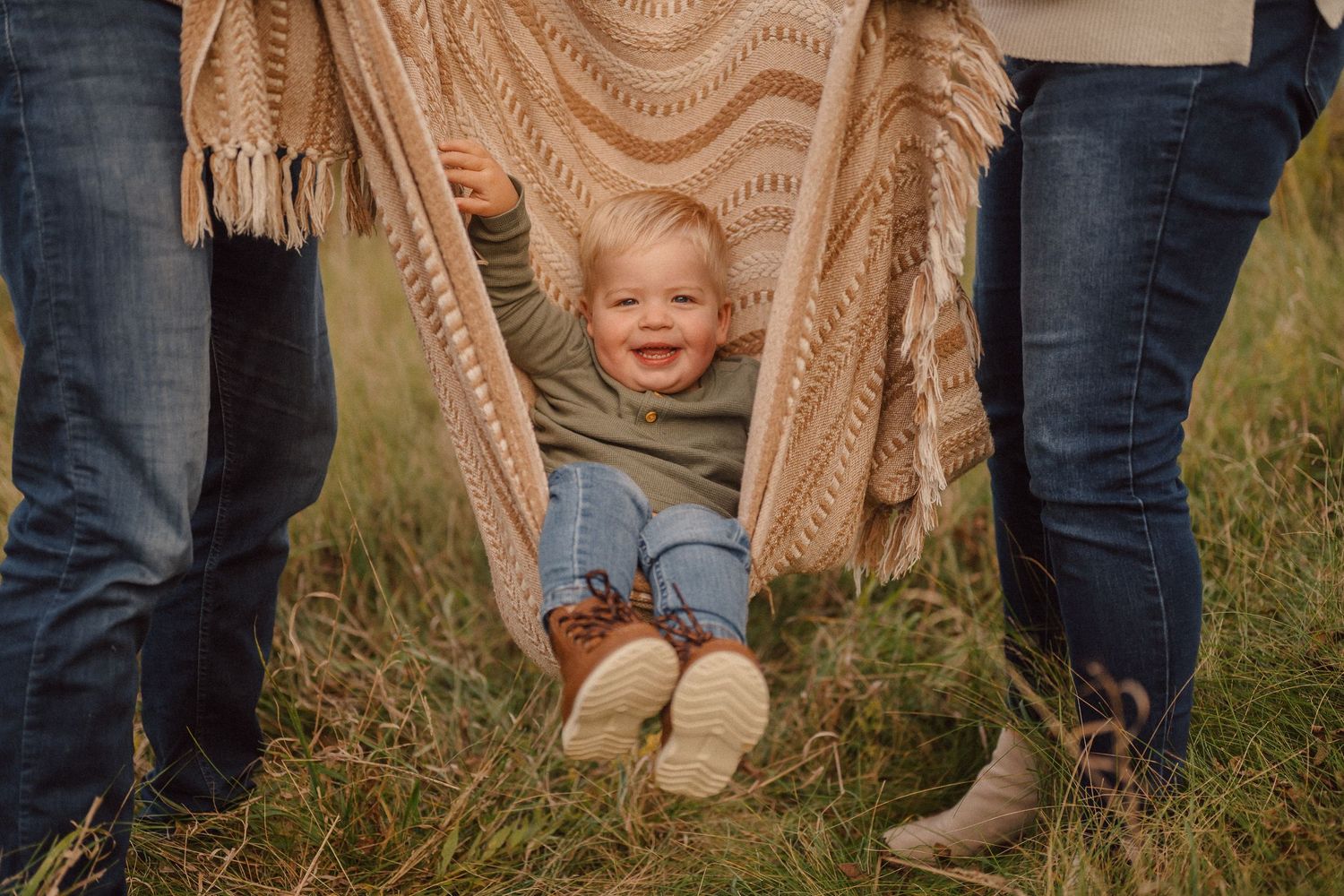 Playful peek-a-boo moments with a blanket in an outdoor setting.