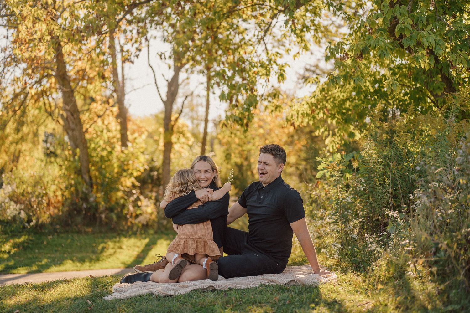 Family enjoying quality time together during sunset photoshoot in nature.