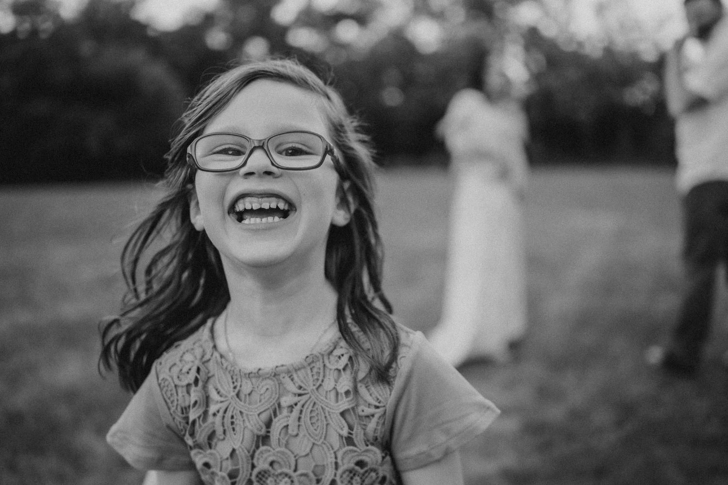 A joyful black and white portrait capturing pure laughter and happiness outdoors.