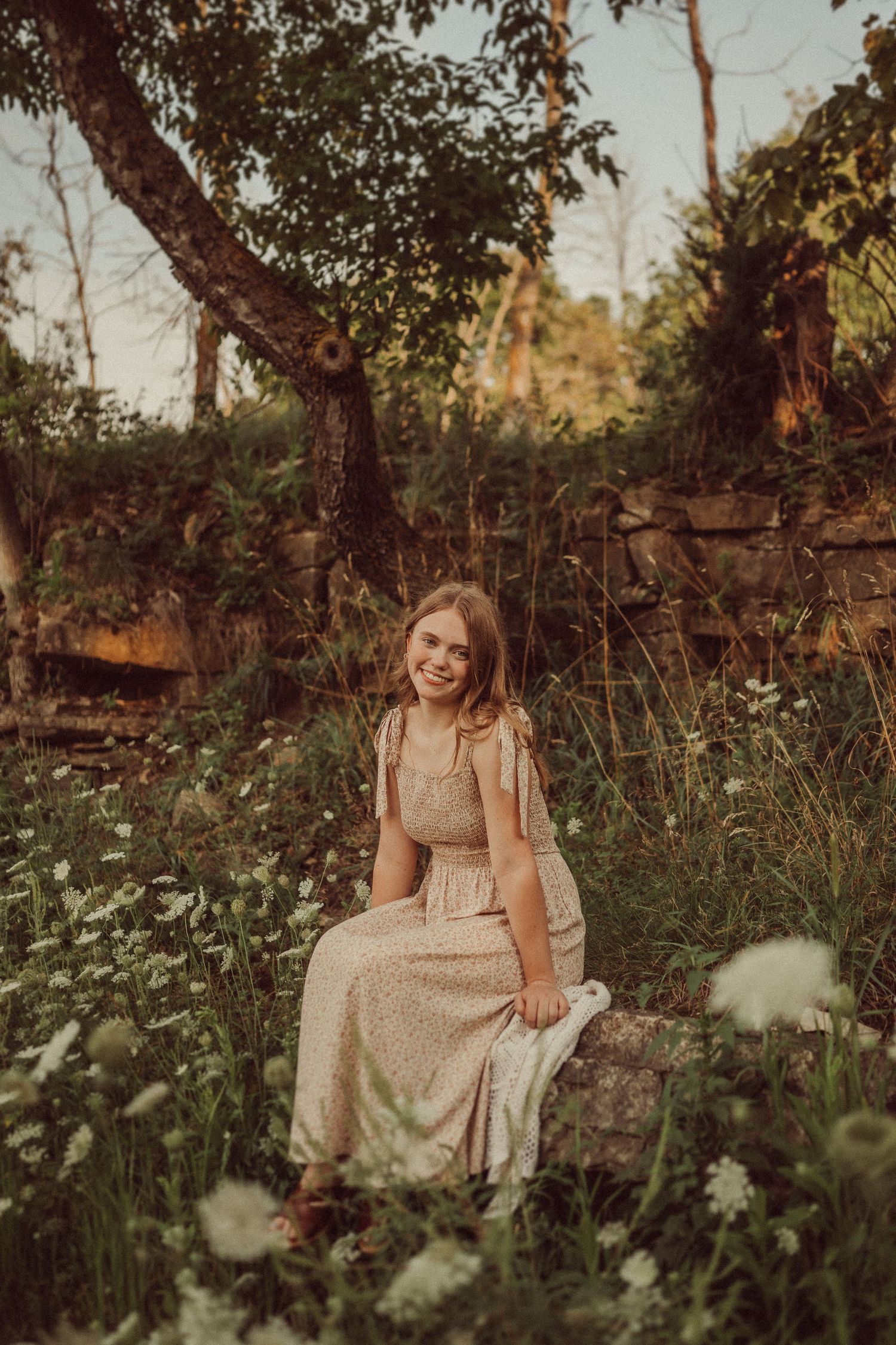 A summer garden portrait featuring a cream dress and white wildflowers in golden afternoon light.