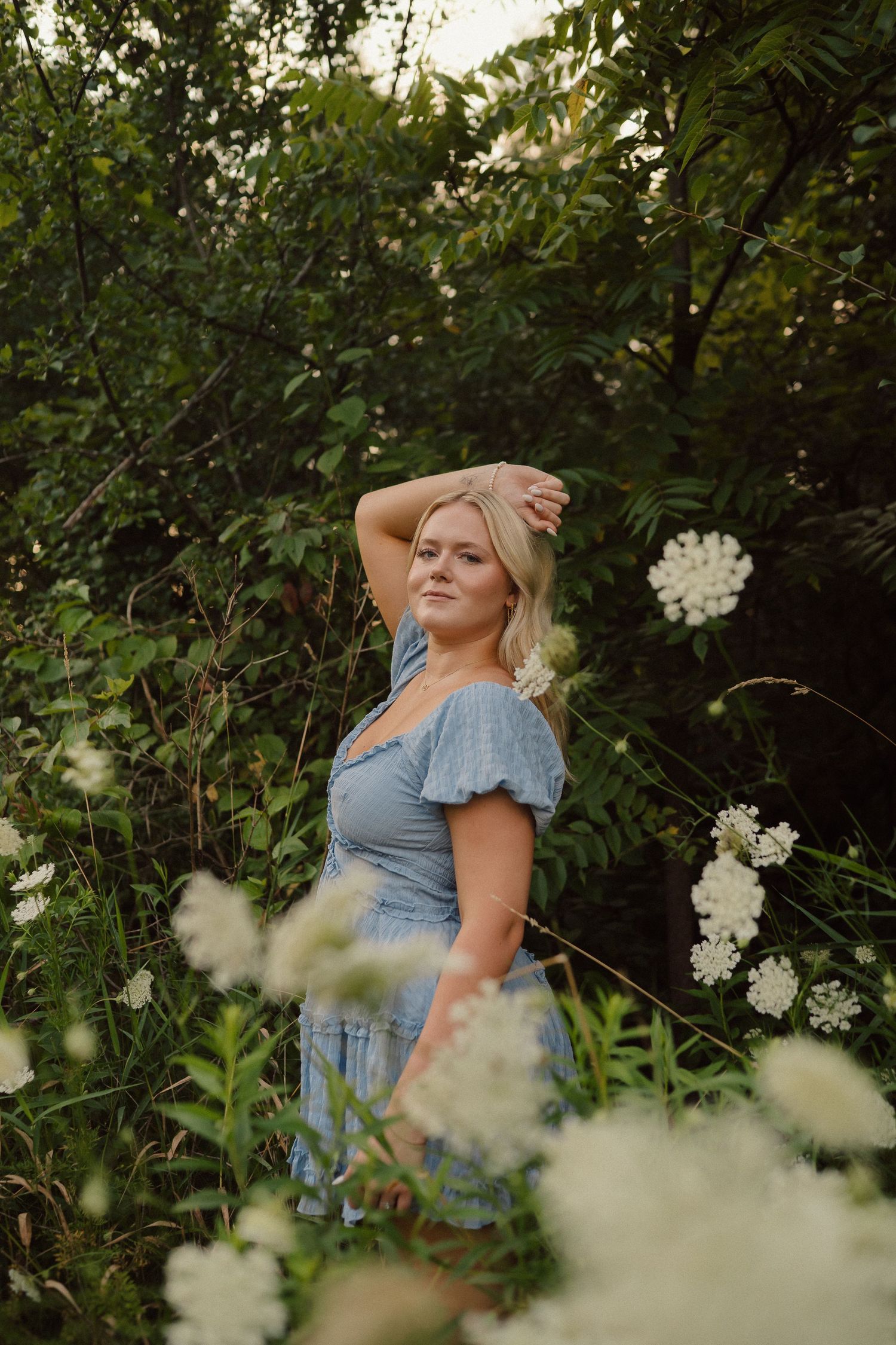 A dreamy portrait session among white wildflowers and green foliage.