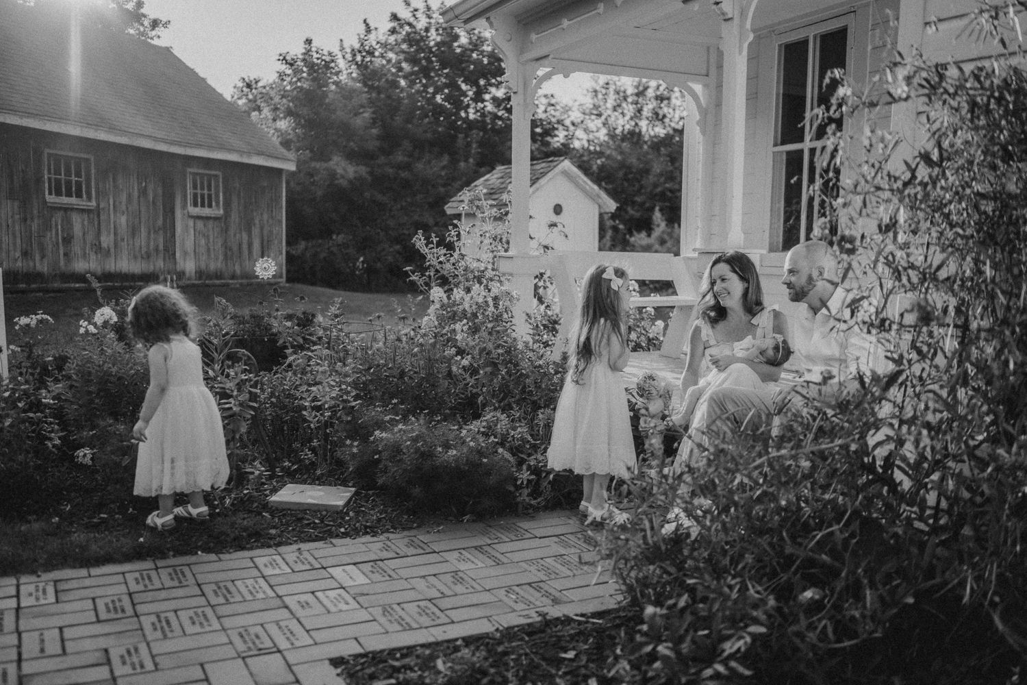 Black and white photo of a peaceful moment in a garden with flowering shrubs.