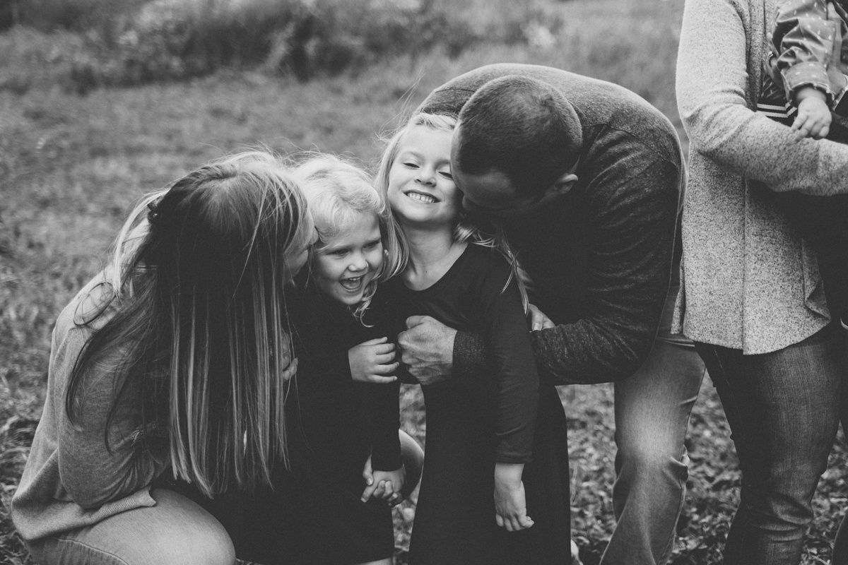 Black and white photo capturing joyful family moment outdoors.