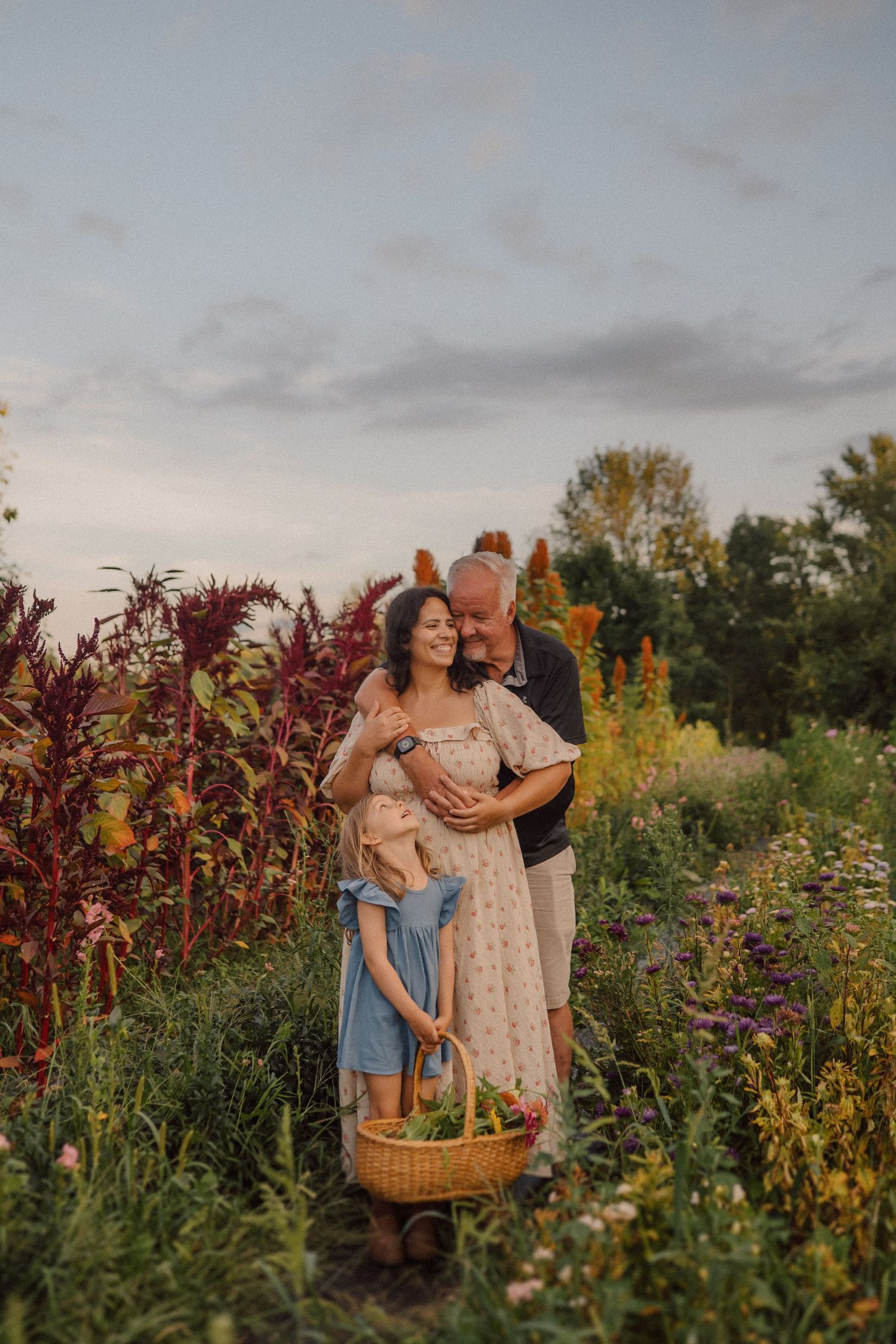 Family gathering flowers in a vibrant wildflower garden during golden hour.