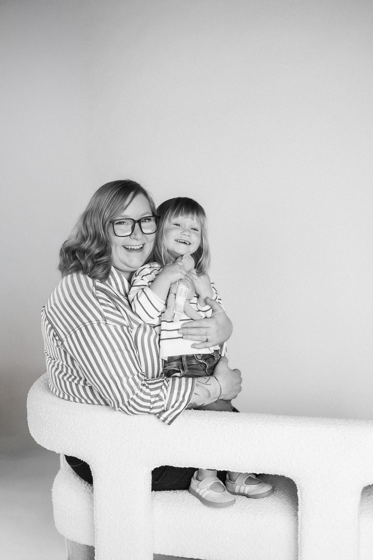 Black and white series showing tender moments between two people on a white couch.