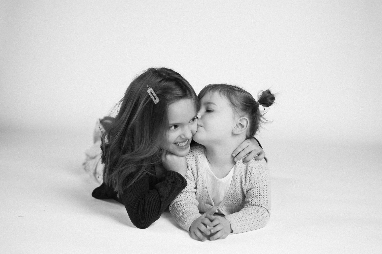 A series of black and white intimate photographs showing tender moments between parent and baby on white background.