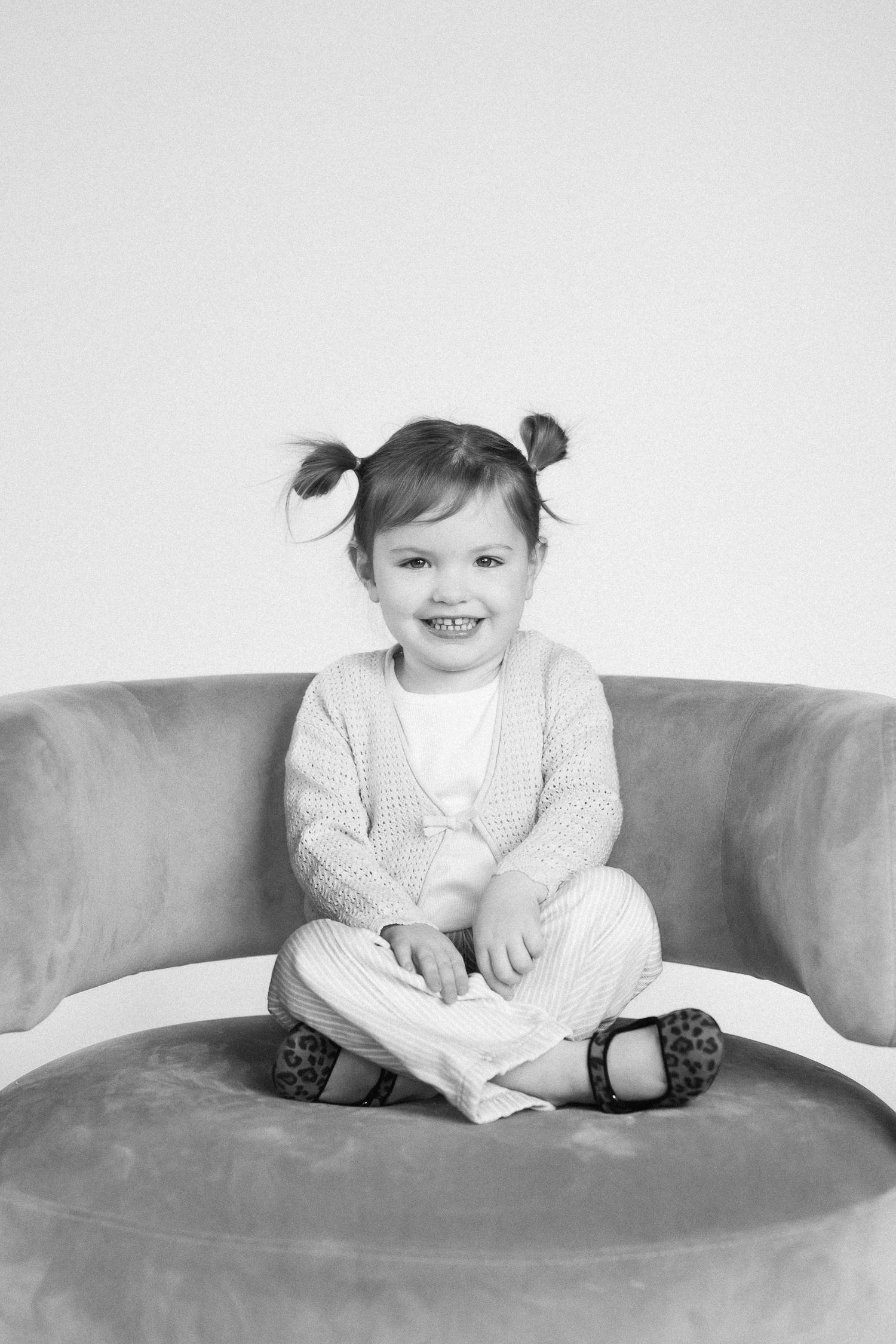 Series of black and white photos showing joyful moments on a curved sofa.