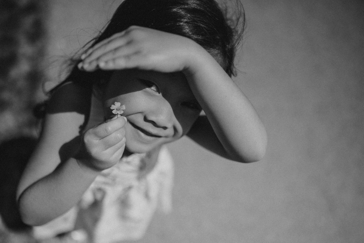 A playful black and white image of someone covering their face with their hands.