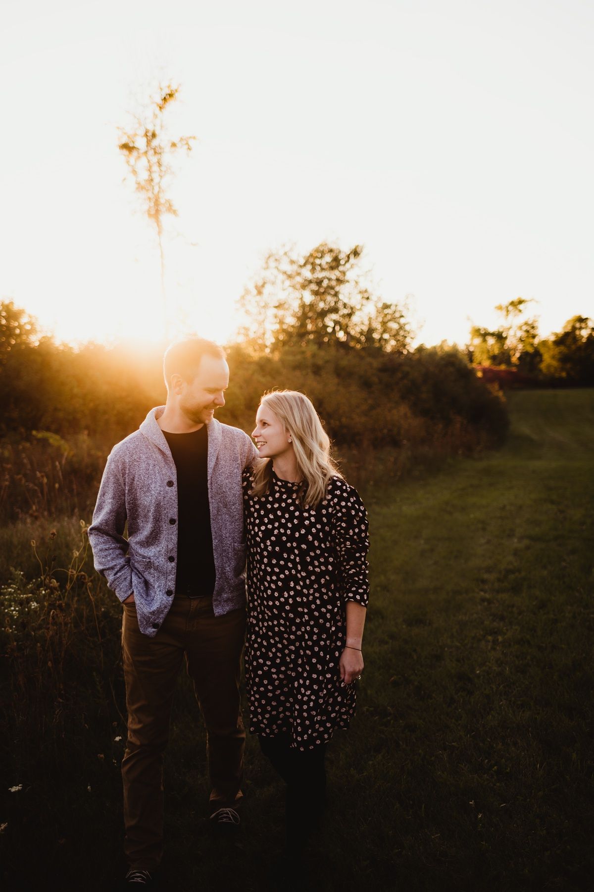 Couple walking together during golden hour sunset in a natural outdoor setting.
