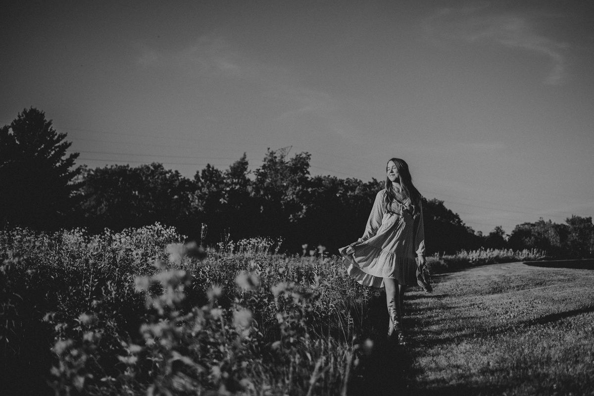 Dramatic black and white silhouette in a wildflower field at sunset.