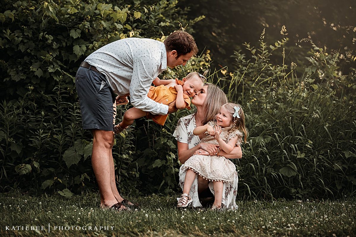 Intimate family moment shared in lush garden setting.