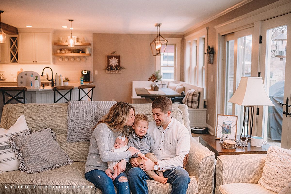 A cozy living room scene with family gathered on a beige couch.