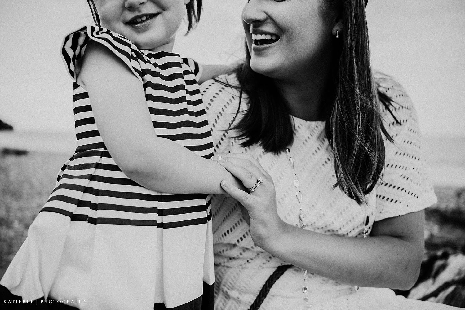A candid black and white portrait capturing laughter and joy between parent and child.