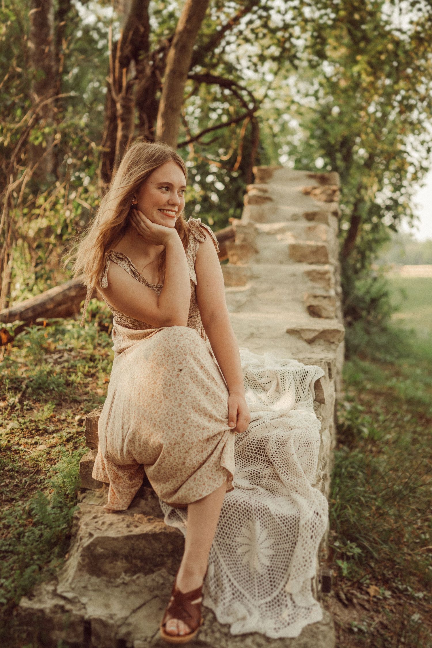 A dreamy portrait in a floral garden with stone steps, featuring a cream-colored dress and natural sunlit setting.