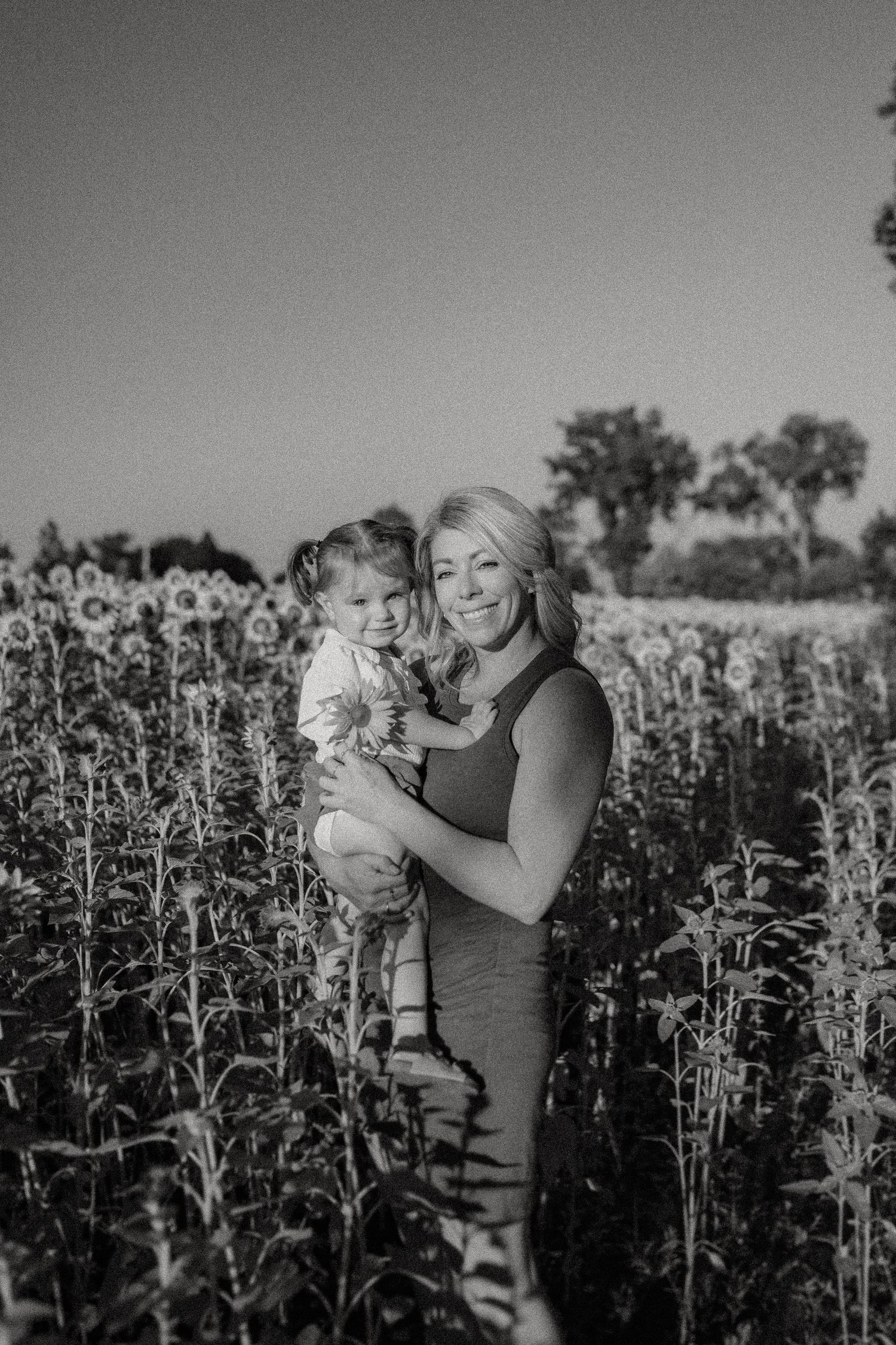 Black and white portrait in a serene sunflower field during summer.