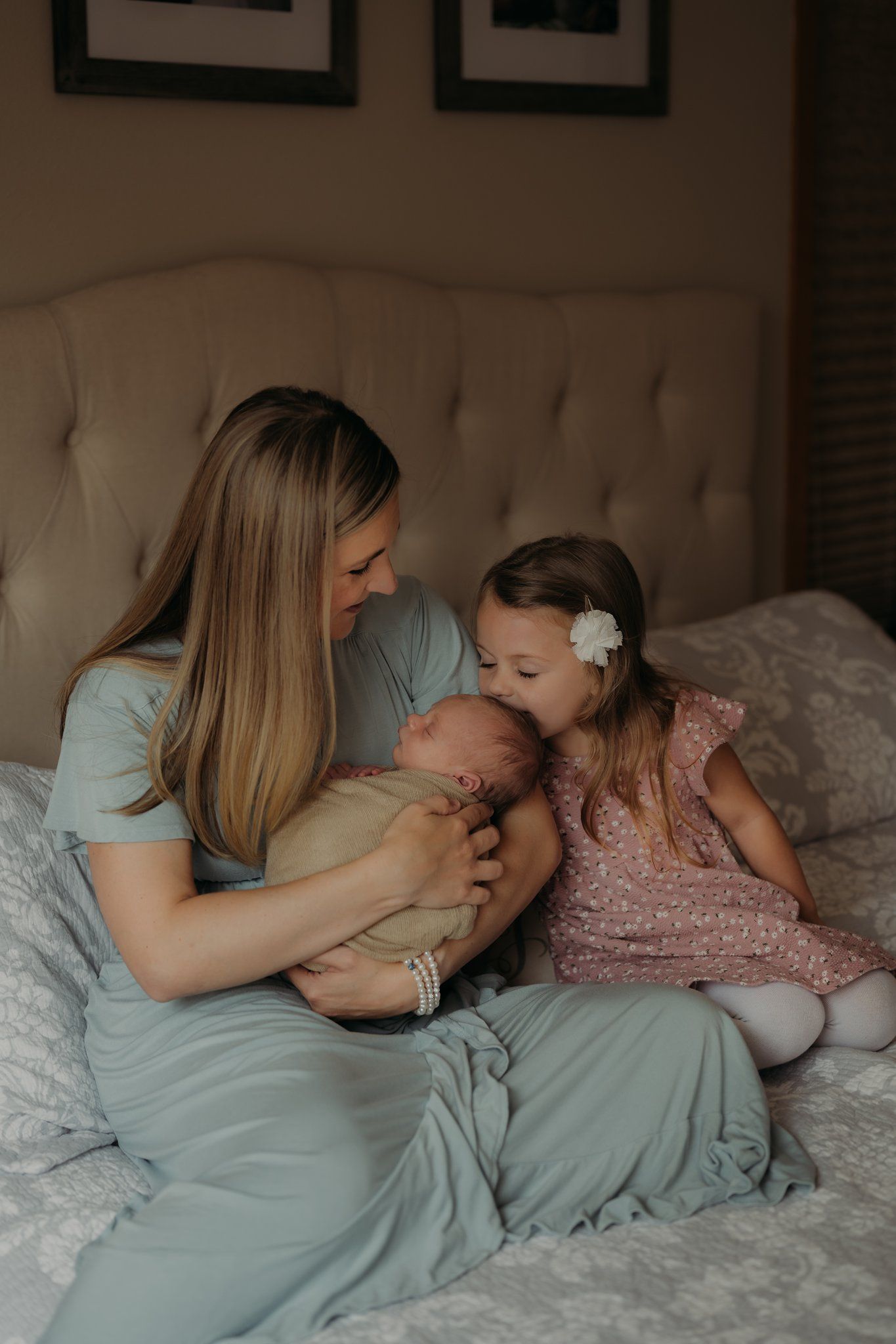 Tender family moment shared on a cozy bed with soft textiles and neutral tones.