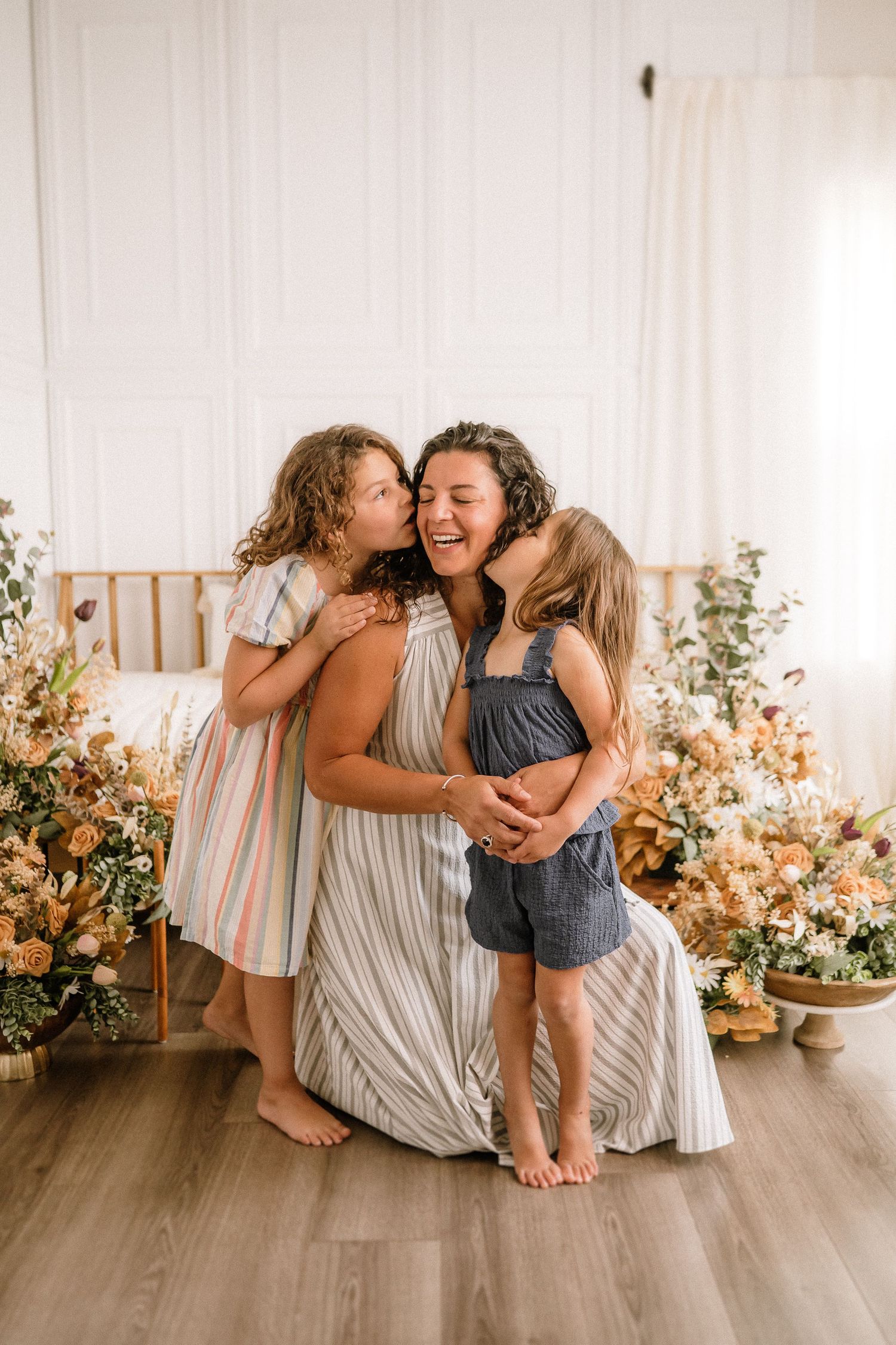Candid family portrait with floral decorations and coordinated outfits.