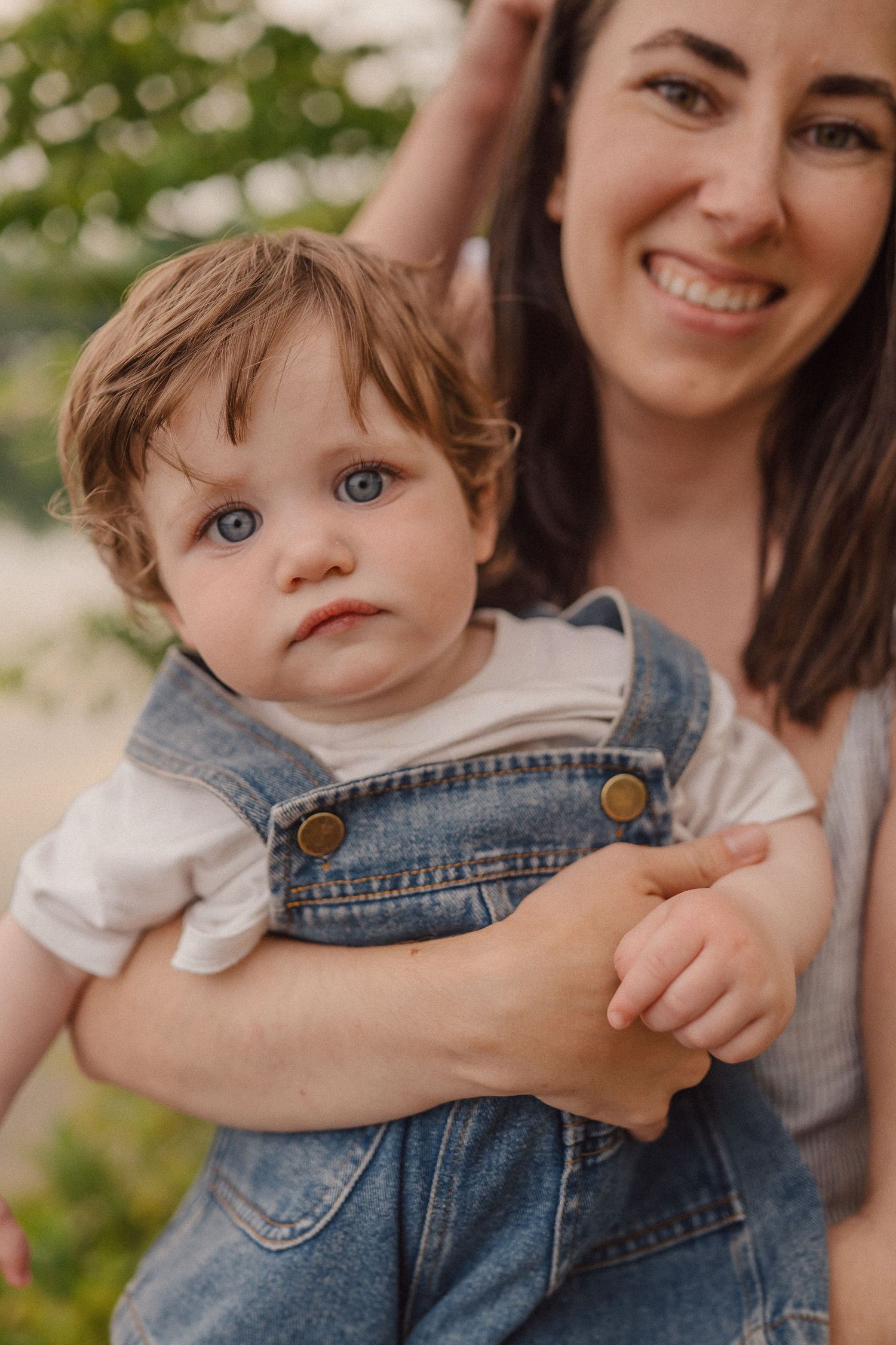 Close-up series of warm family moments in an outdoor summer setting with denim overalls.