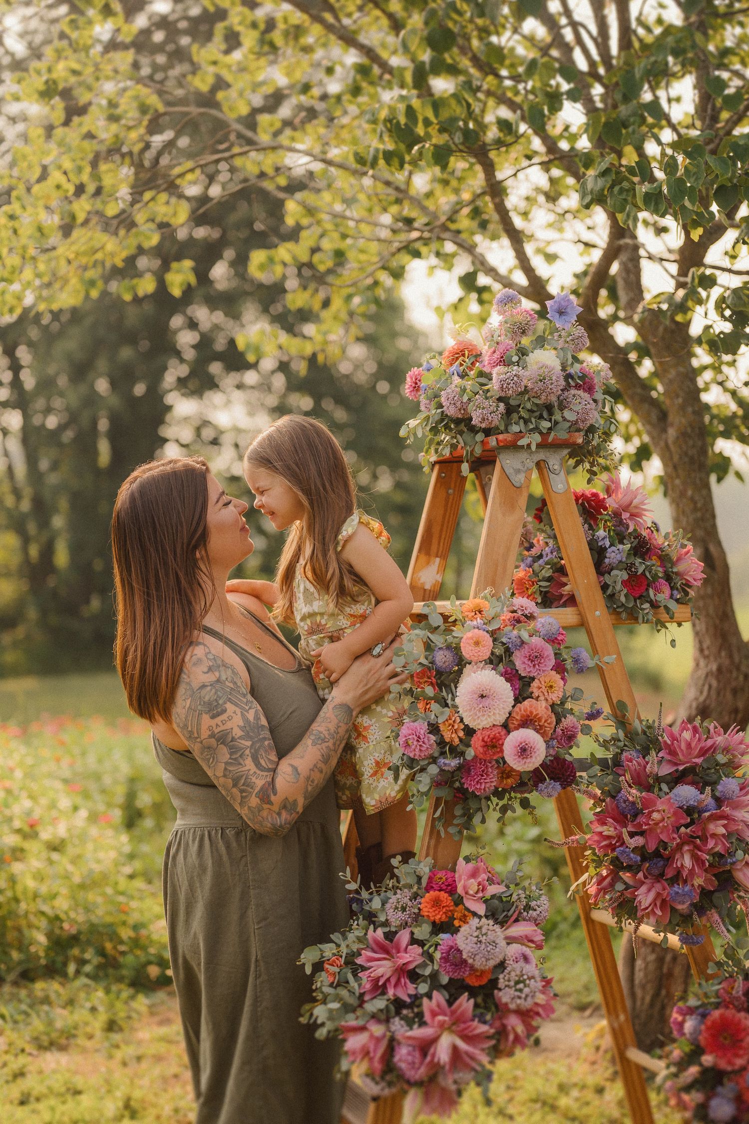 Floral photography session in a garden with wooden stands decorated with pink and purple blooms.
