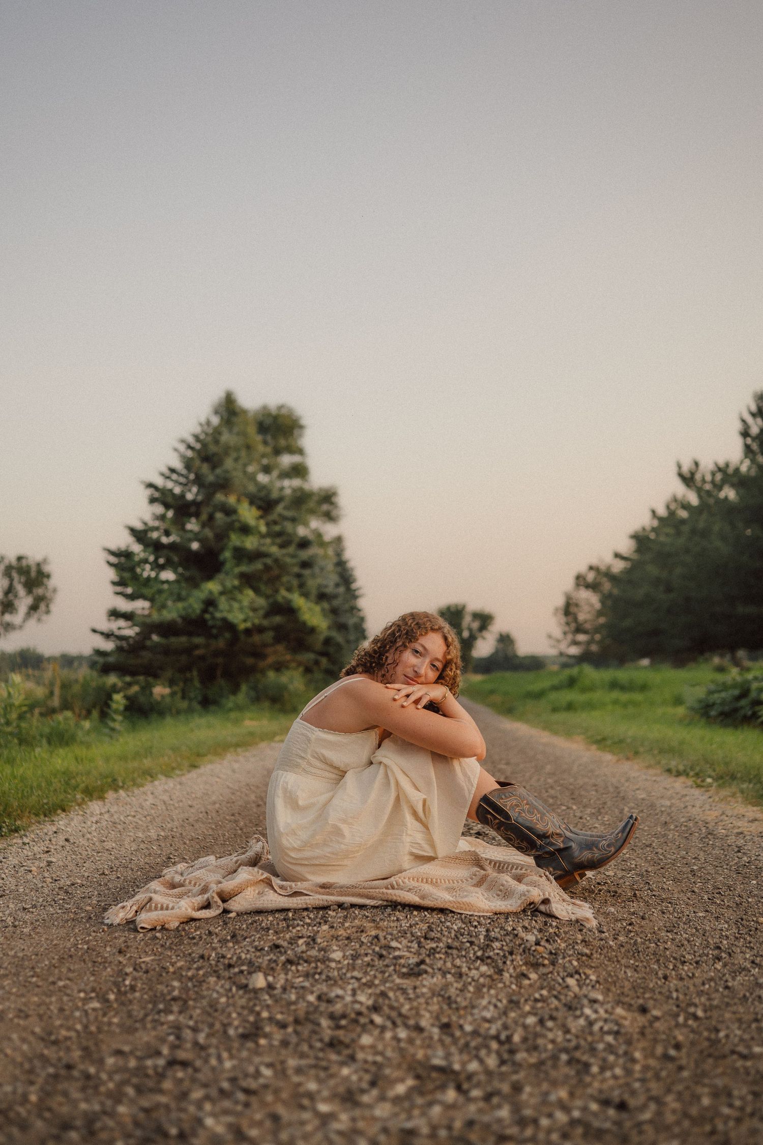 A dreamy black and white photo series on a gravel road surrounded by trees at dusk.