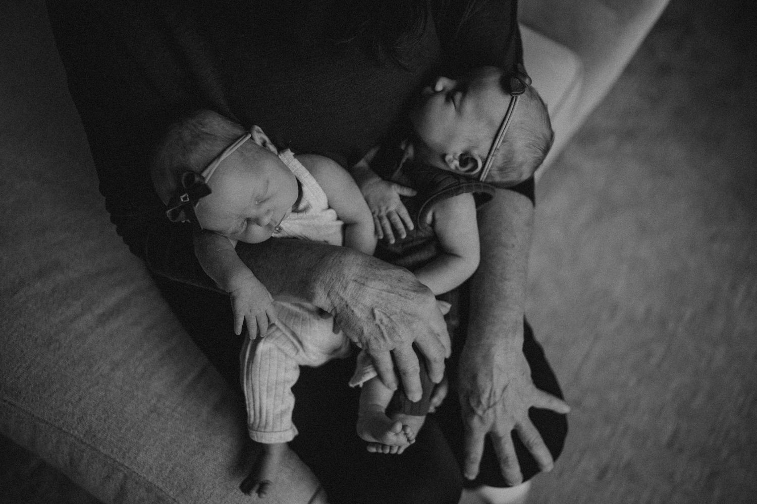 A tender black and white portrait of caregiver holding and bonding with infant.