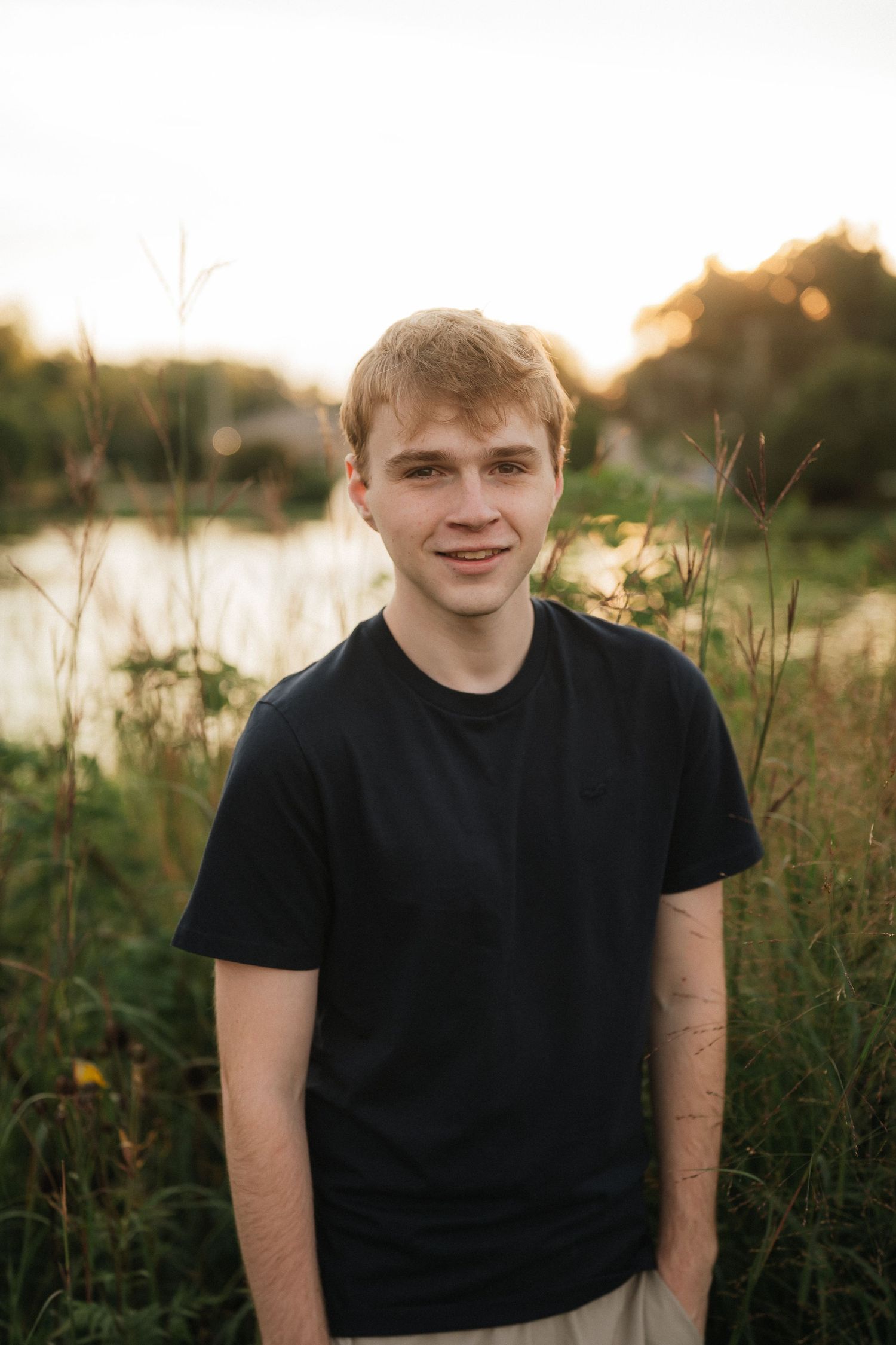 Outdoor portraits at sunset wearing a black t-shirt with golden hour lighting and natural scenery.