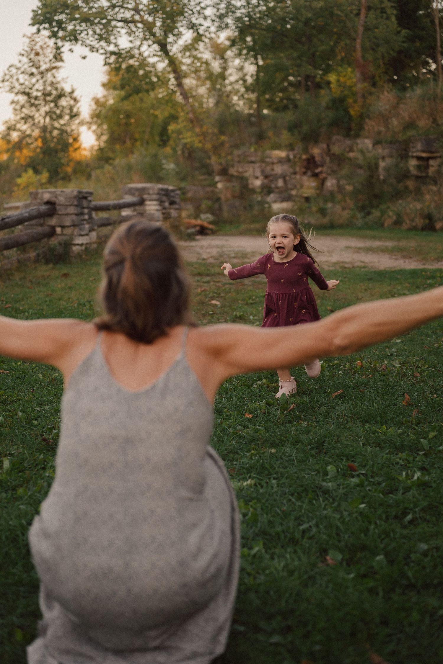 A heartwarming outdoor scene of play and connection between two people on a grassy area during golden hour.