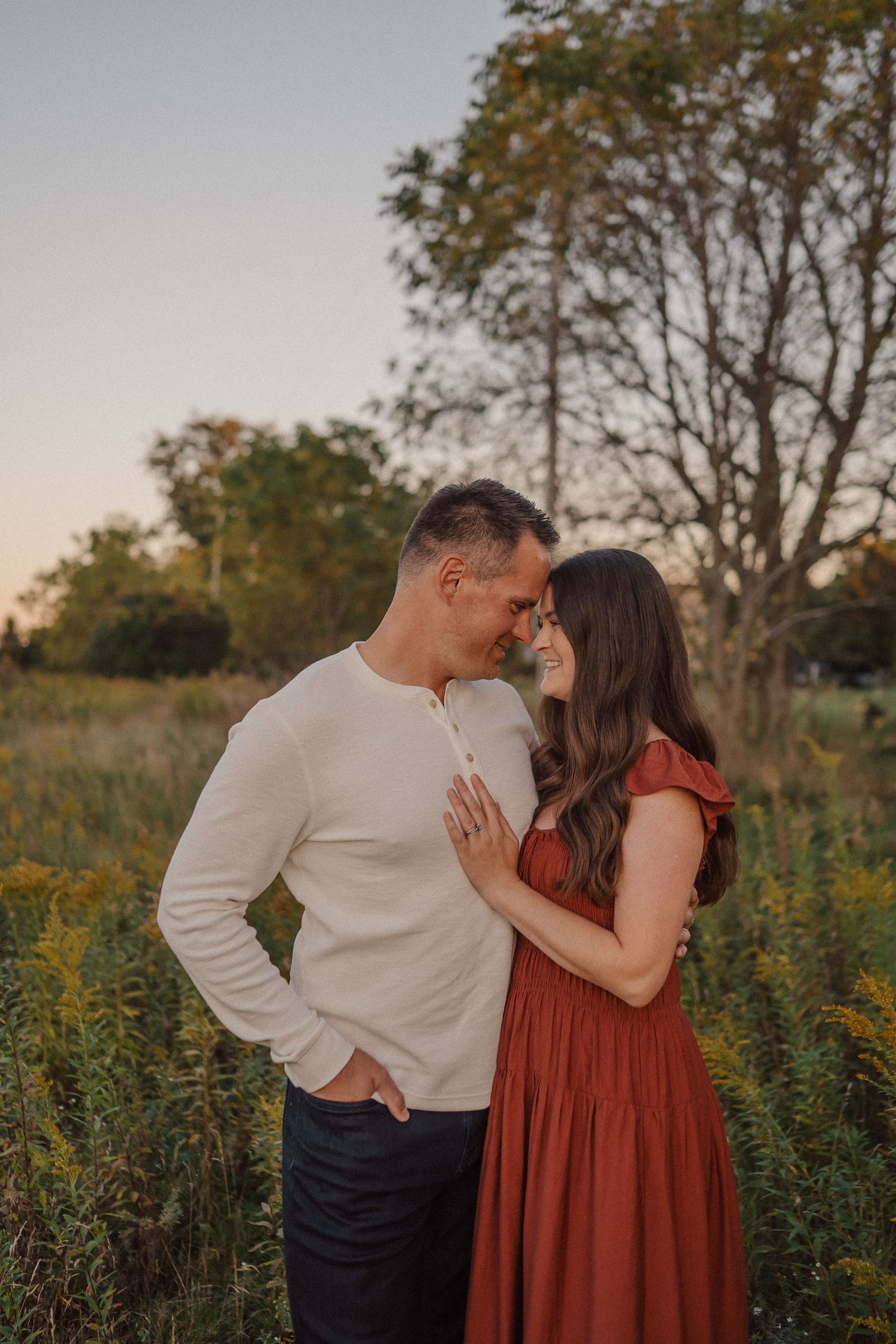 Romantic couple shares an intimate moment in a wildflower field during golden hour.