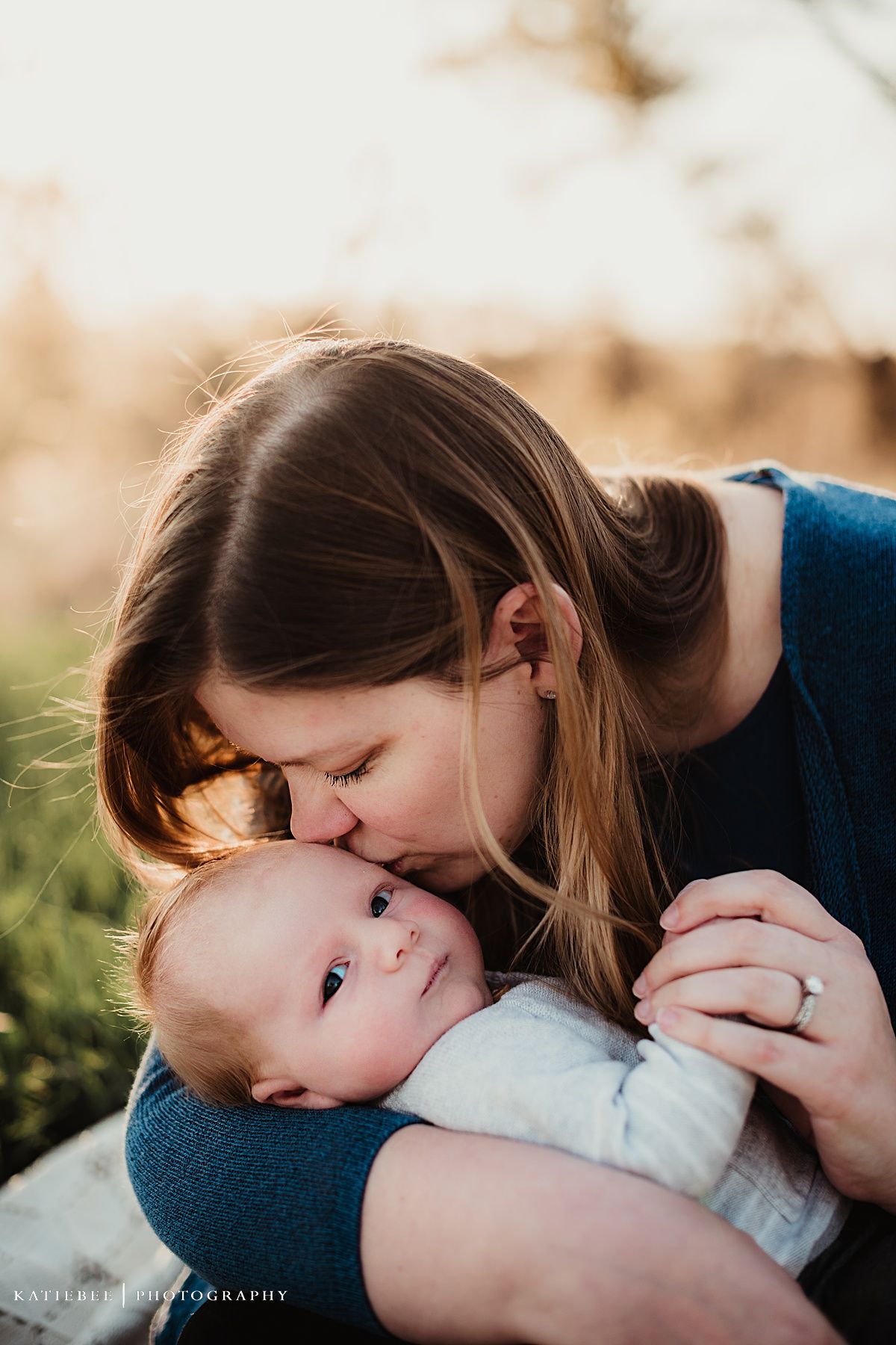 An intimate portrait of tender affection between parent and infant in warm golden light.