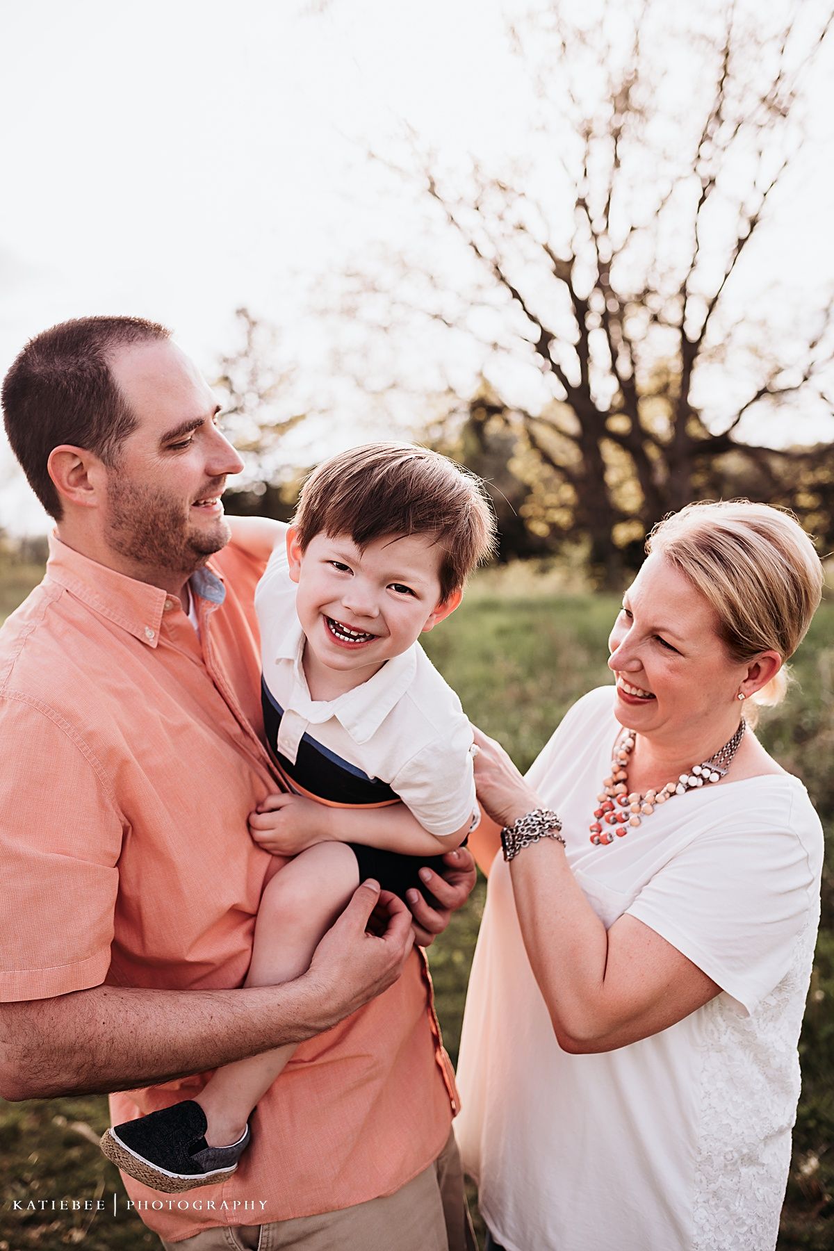 Candid family portrait showing shared laughter in an outdoor spring setting.