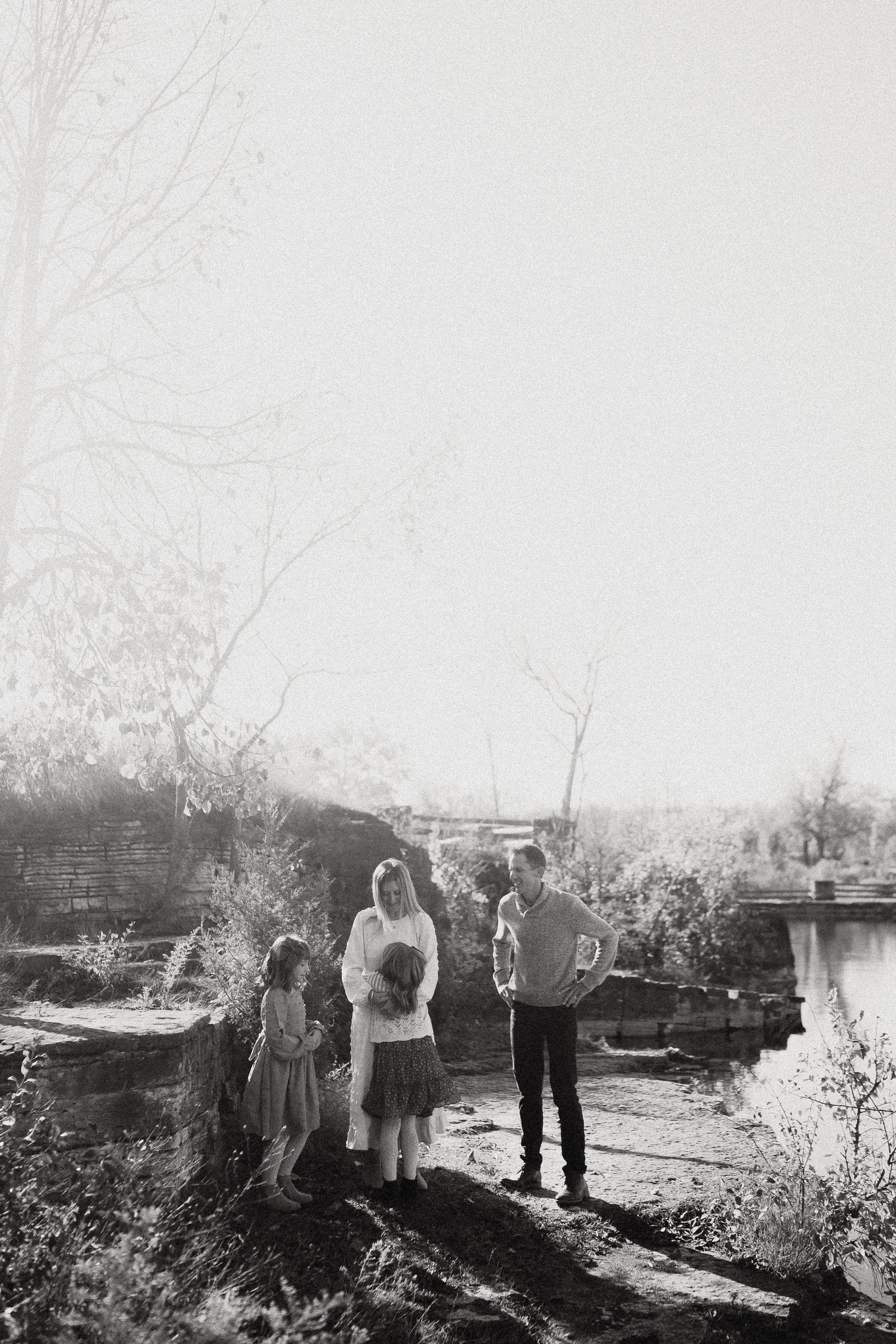 Black and white landscape photograph showing silhouettes of people gathered outdoors.