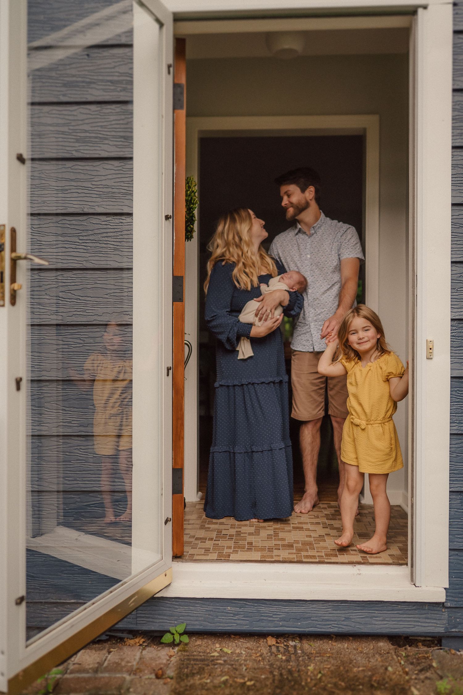 Series of family portraits framed in white doorway of house exterior.
