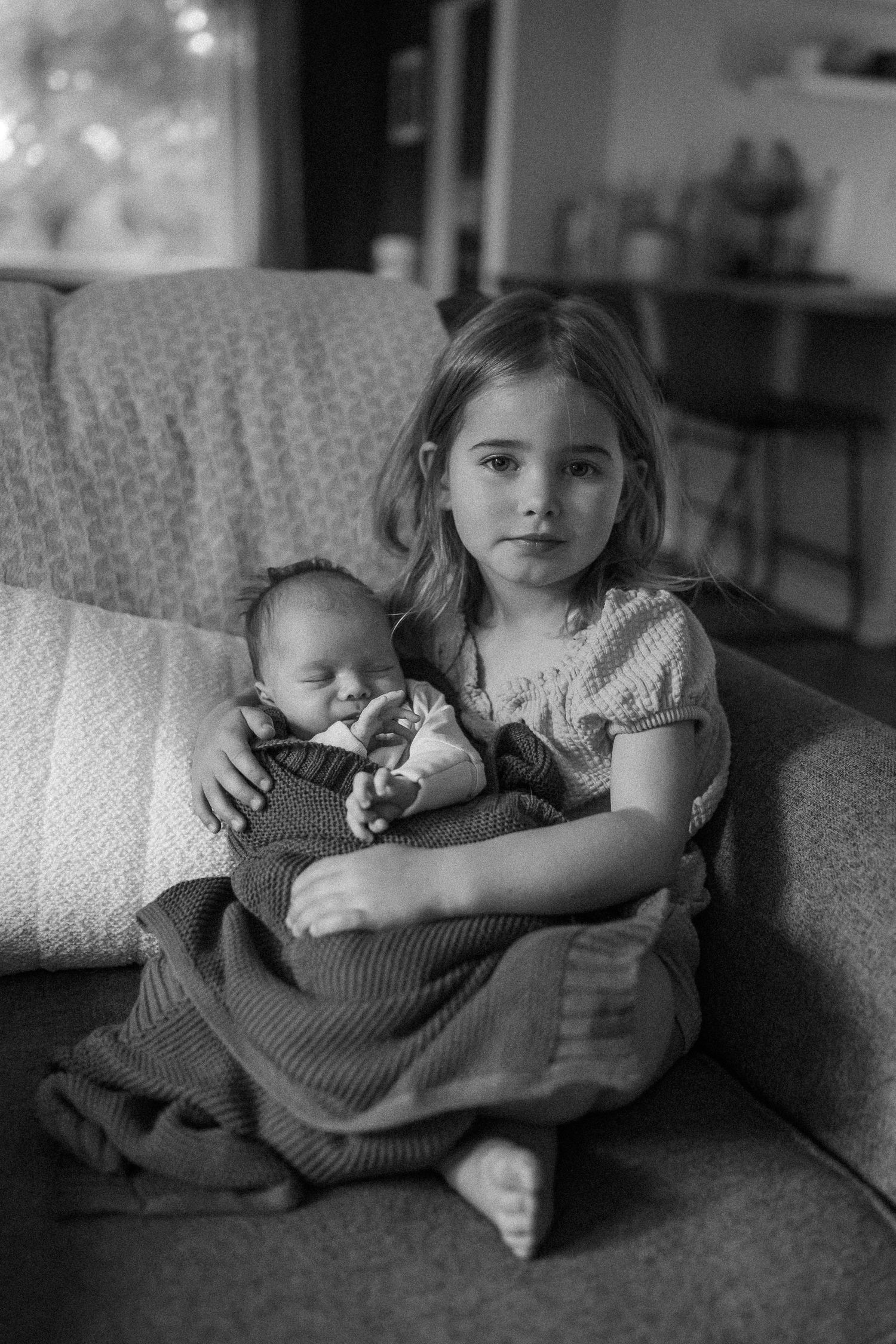 Black and white series showing gentle moments on living room sofa.