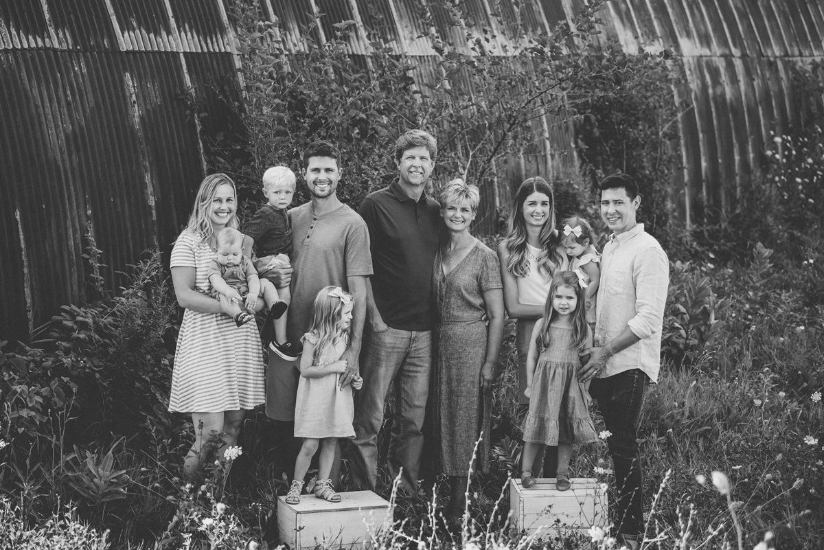 Black and white group portrait of extended family members standing together outdoors.