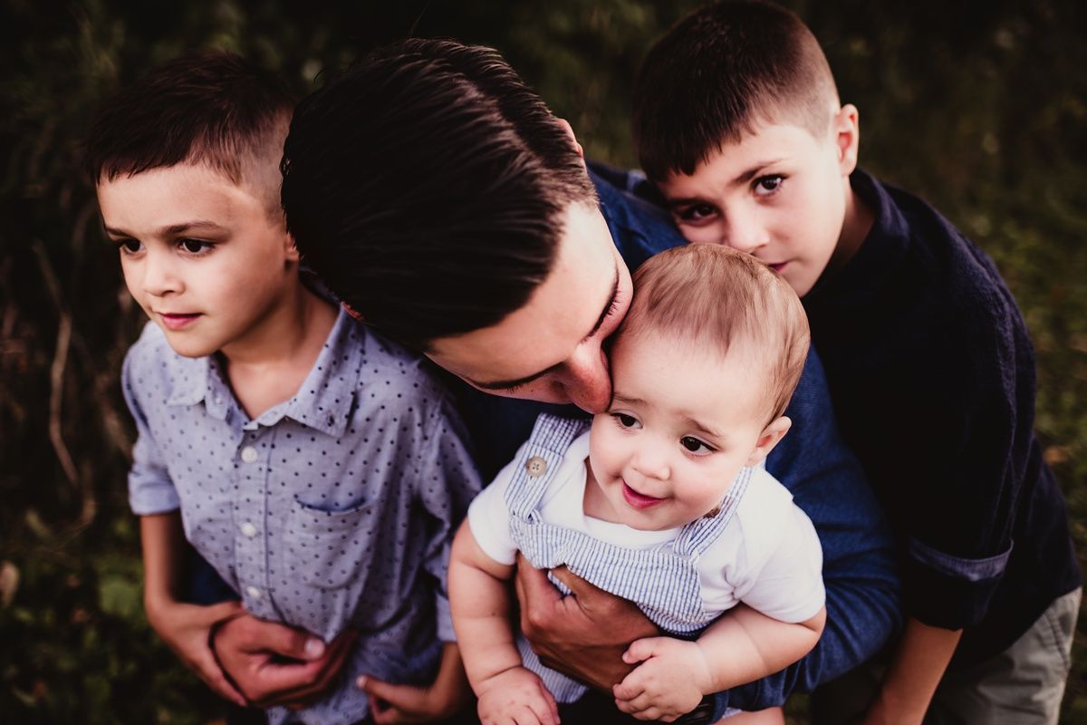 Close-up candid shot of family members huddled together outdoors.