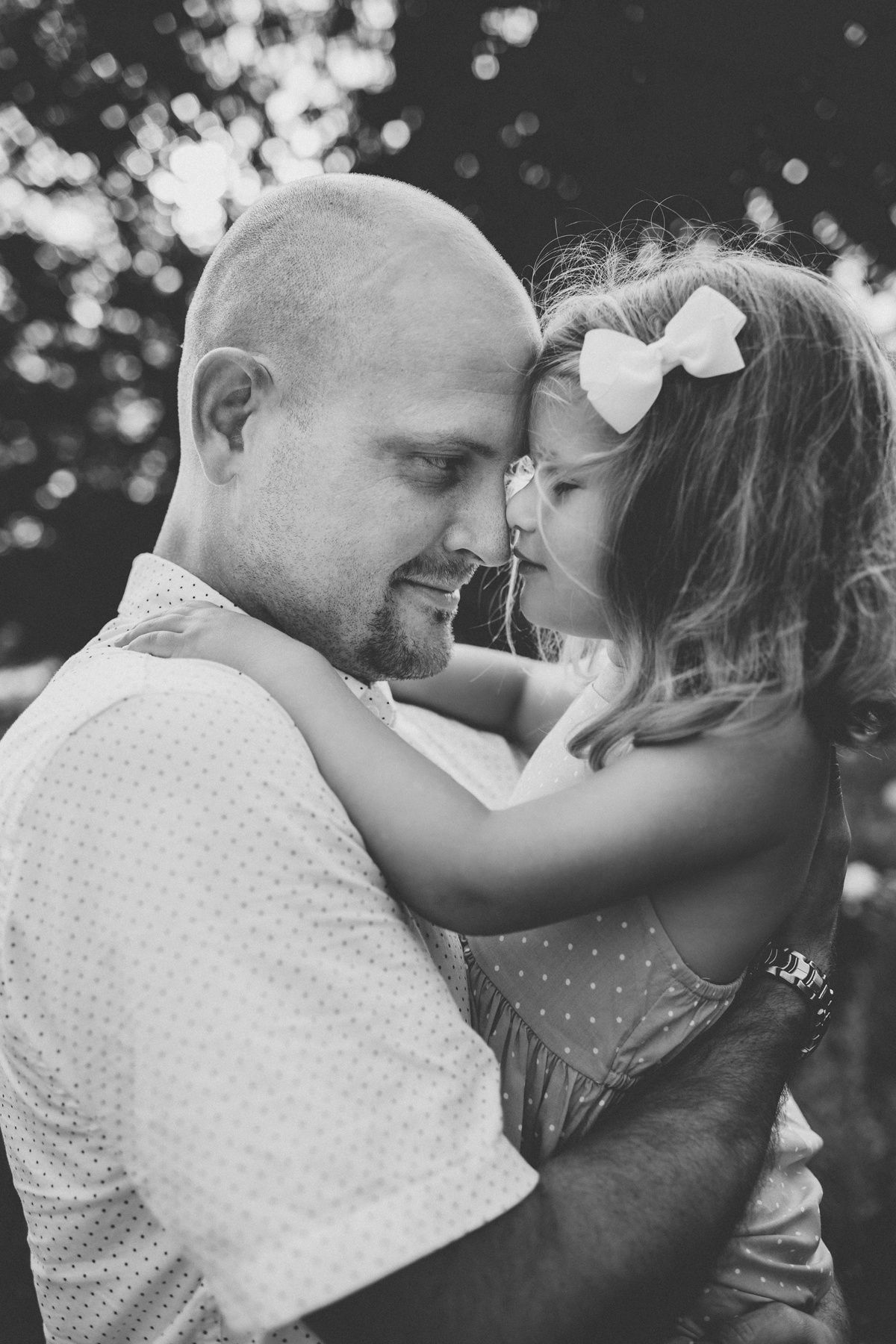 Tender black and white portrait showing close embrace in natural setting.