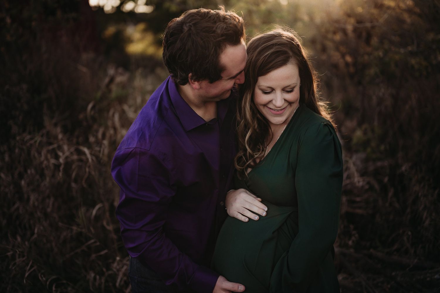 An intimate maternity portrait of a couple sharing a tender moment at sunset.