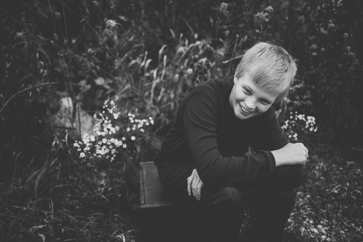 A black and white candid portrait captures laughter while sitting outdoors.