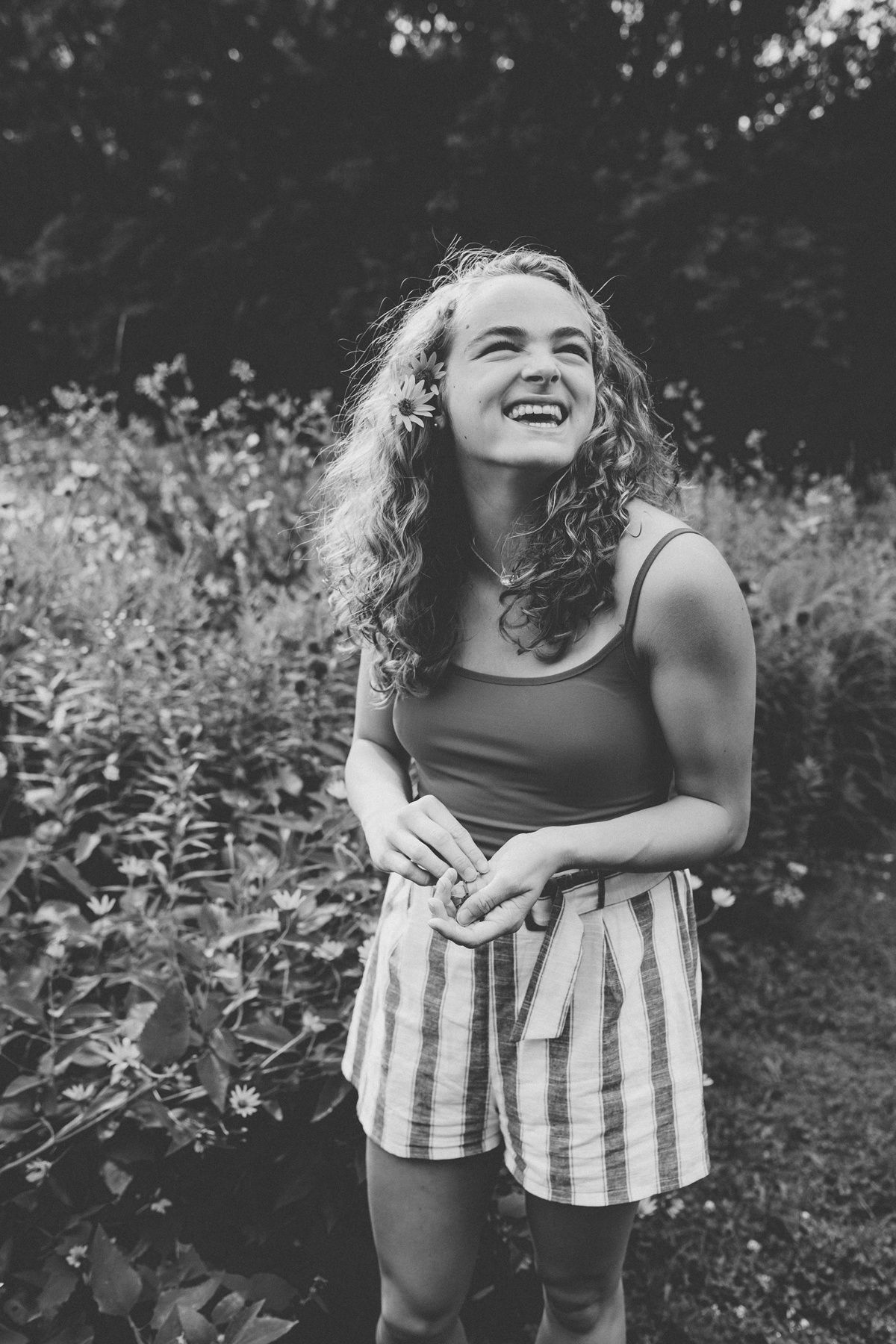 Black and white candid portrait in a garden setting with natural expressions.