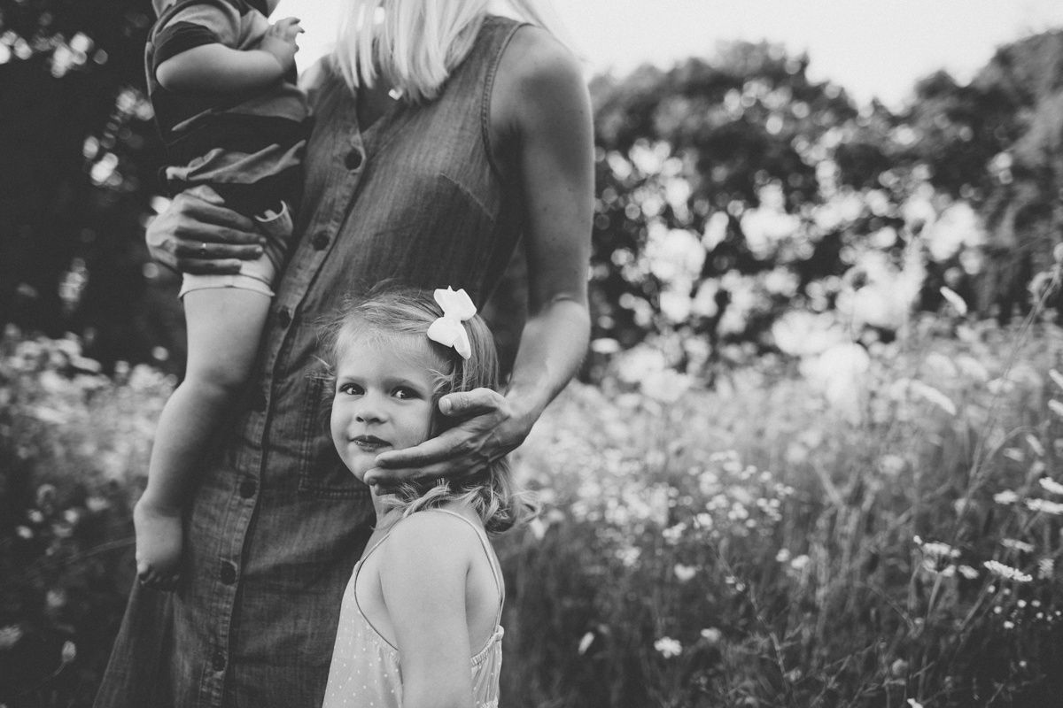 Black and white portrait in a meadow with wildflowers and tall grass.