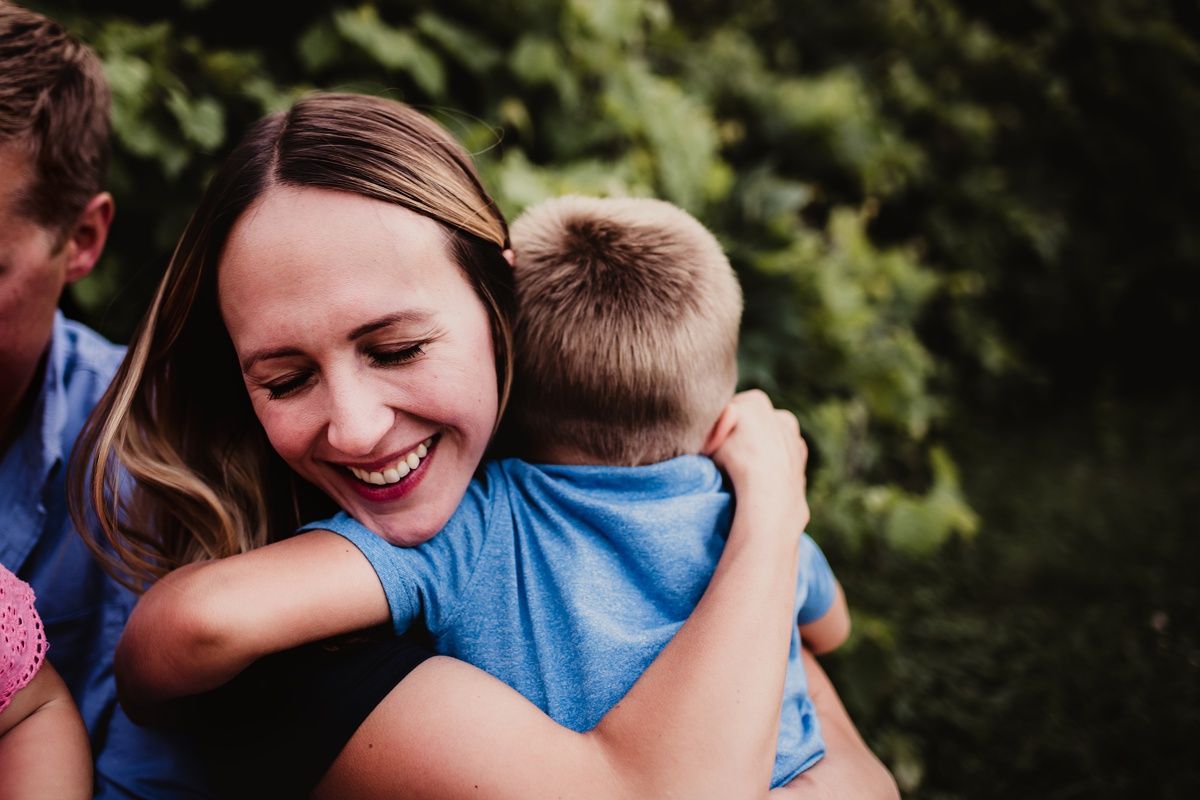 Heartwarming embrace between family members captured in natural outdoor lighting.