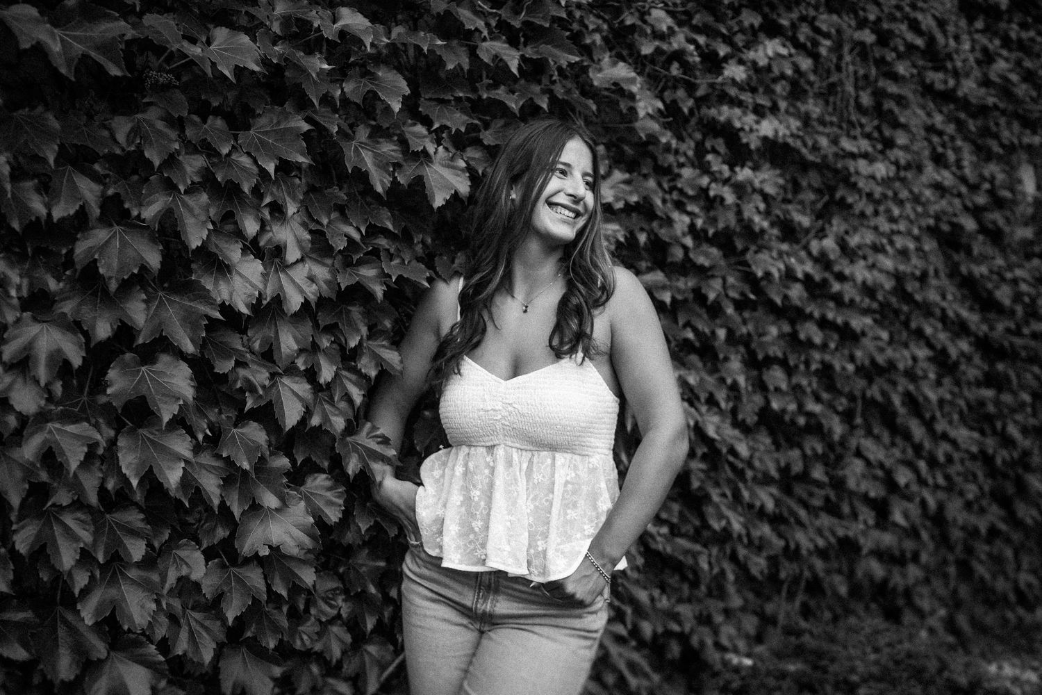 Artistic black and white portraits against an ivy-covered wall background.
