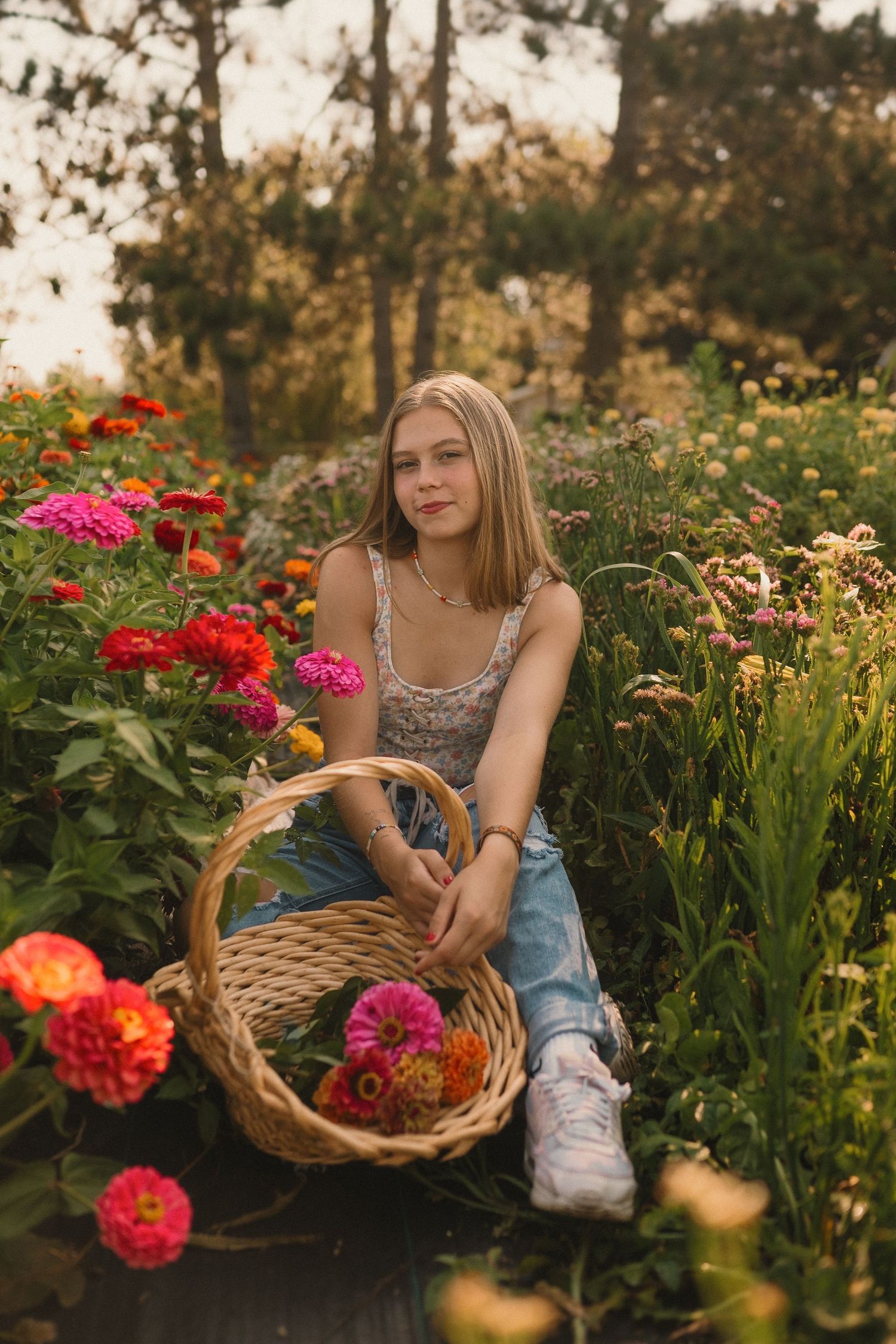 A woven basket filled with colorful flowers sits in a vibrant garden during golden hour.