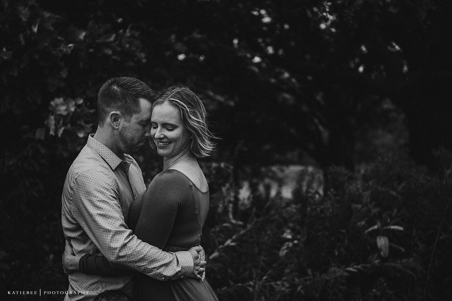 Intimate black and white portrait in a natural wooded setting.