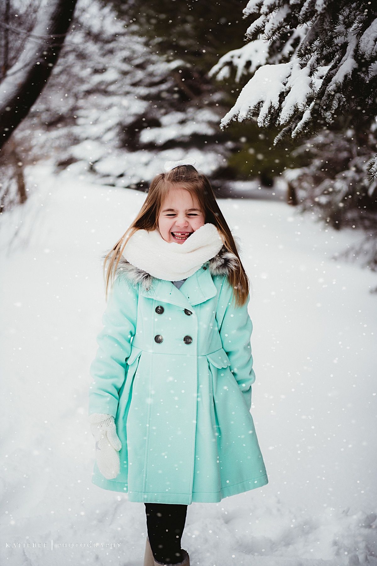 Joyful winter scene with a mint green peacoat and white scarf amid falling snow.