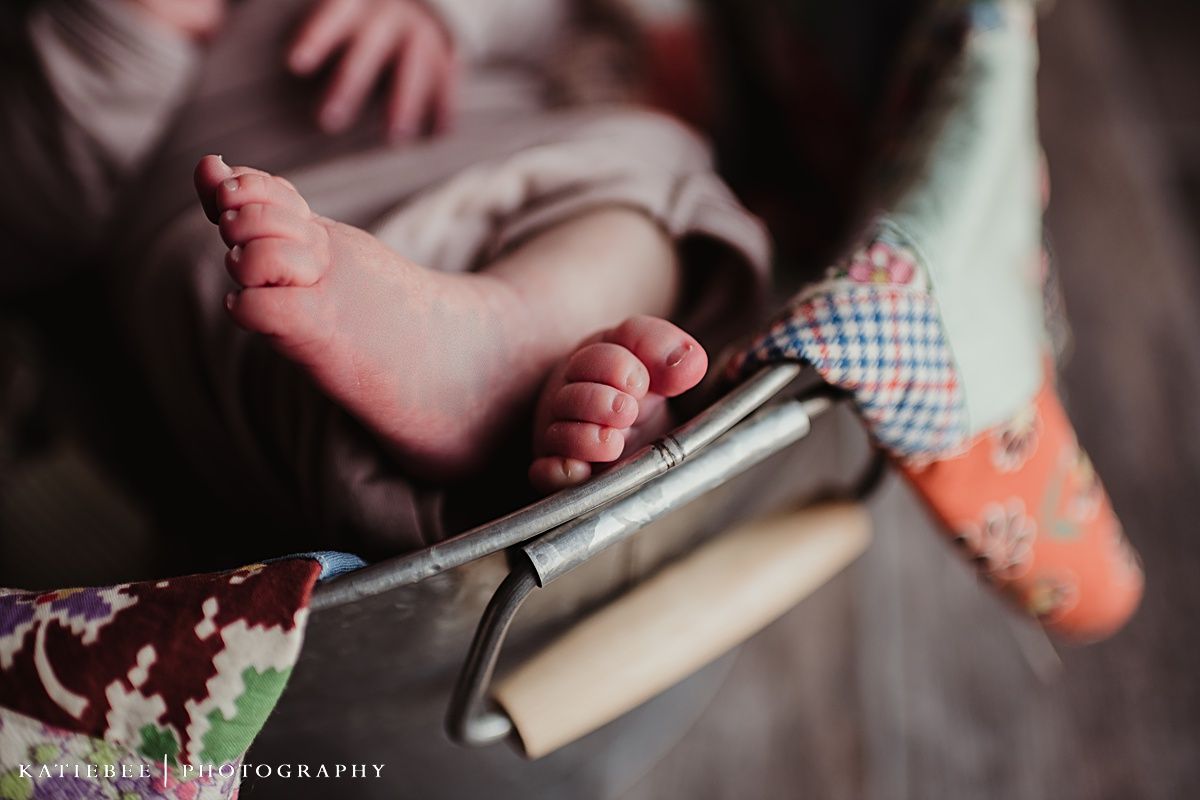 Close-up of tiny baby feet resting on patterned fabric.